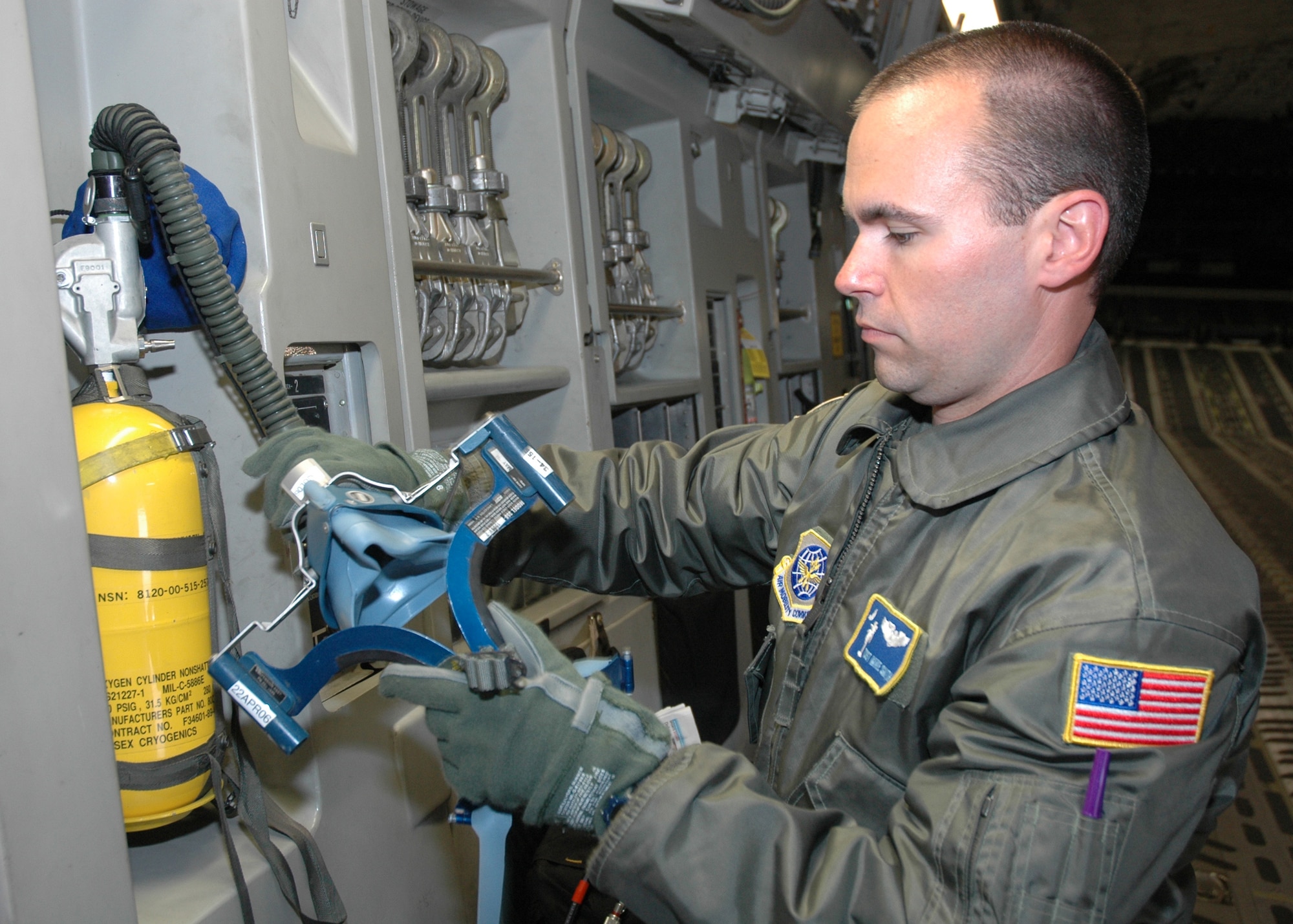 Tech. Sgt. Mike Smith, a reserve loadmaster with the 300th Airlift Squadron, Charleston AFB, S.C., checks an oxygen mask as part of his preflight check list aboard a C-17 Globemaster III, during a recent training mission.  (Photo by 1st Lt. Wayne Capps, USAFR)