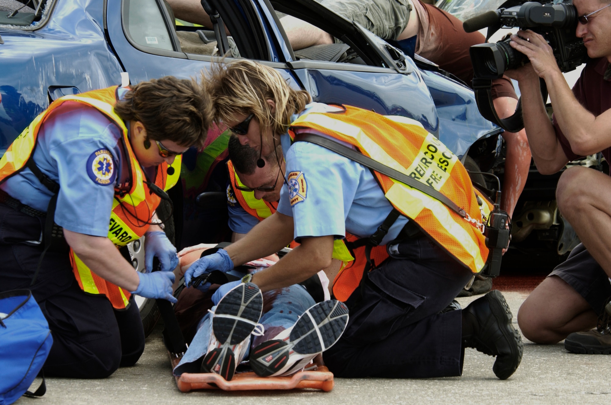 A reporter captures a shot of the rescue team from Brevard County, Fla., as they prepare an "accident" victim for transport to a hospital on Tuesday, April 11, 2006, during Operation NOW events at Patrick Air Force Base, Fla. NOW, which stands for Not on Our Watch, is a graphic, "in your face" program designed to scare teens into safer driving habits. Approximately 800 high school seniors attended the first day of the three-day event. (U.S. Air Force photo/Master Sgt. Jack Braden)