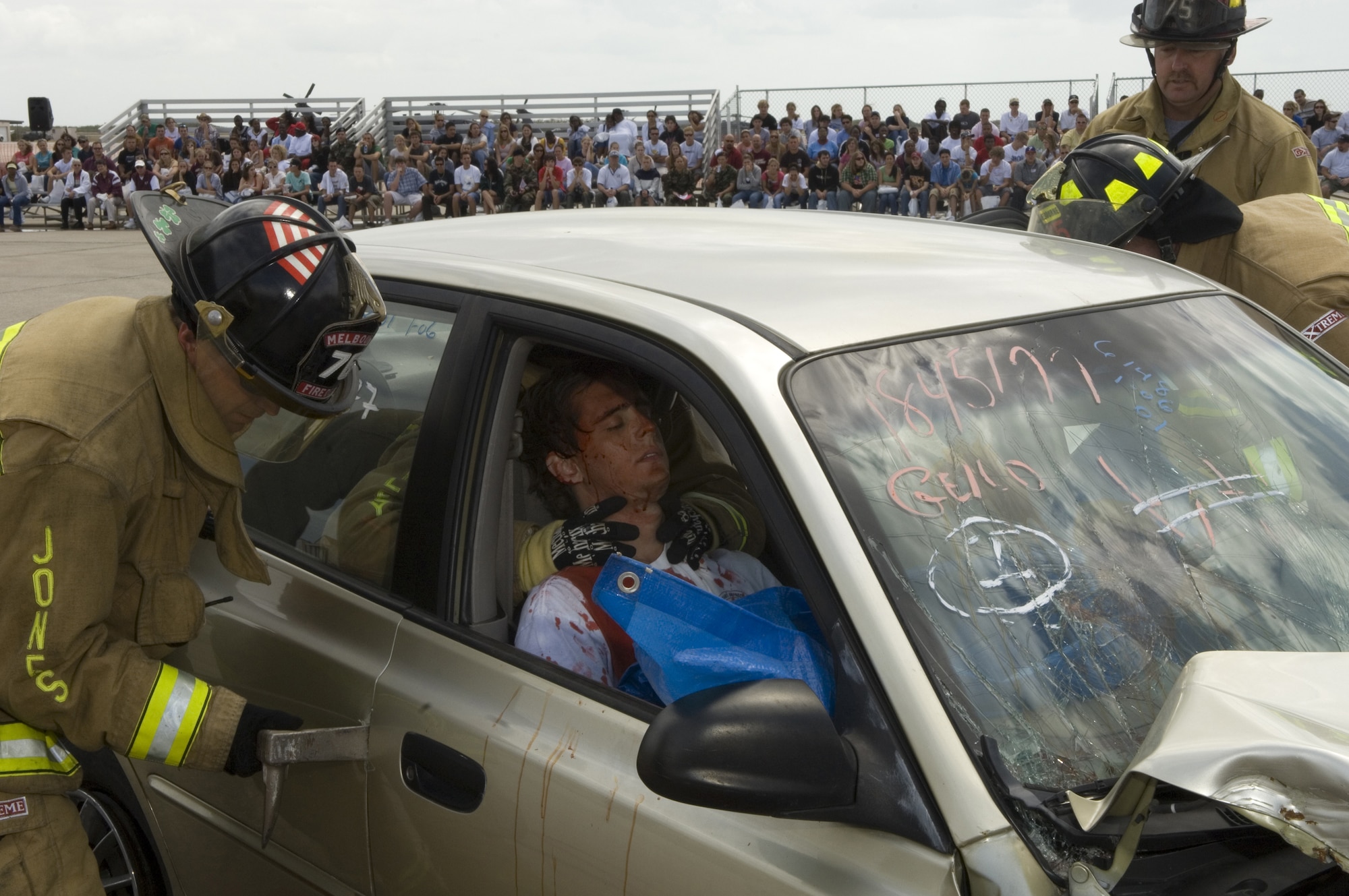 High school seniors watch as a rescue team from Brevard County, Fla., prepares an "accident" victim for extraction from a wrecked car Tuesday, April 11, 2006, during Operation NOW events at Patrick Air Force Base, Fla. NOW -- which stands for Not on Our Watch -- is designed to scare teens into safer driving habits. Approximately 800 high school seniors attended the first day of the three-day event. (U.S. Air Force photo/Master Sgt. Jack Braden)