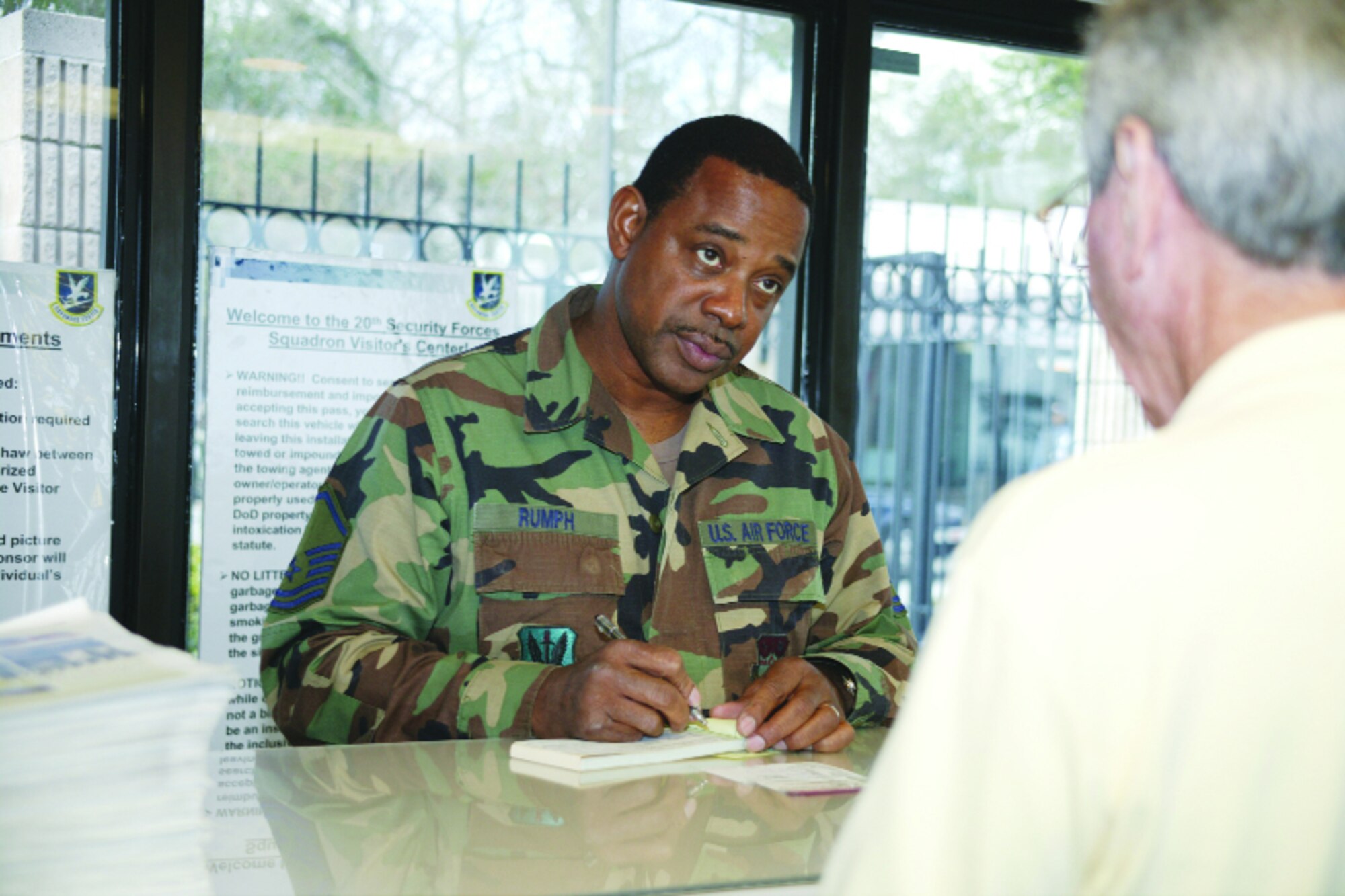 Master Sgt. Timothy Rumph, 20th SFS, fills out a visitor's pass for a custome at Shaw AFB.   