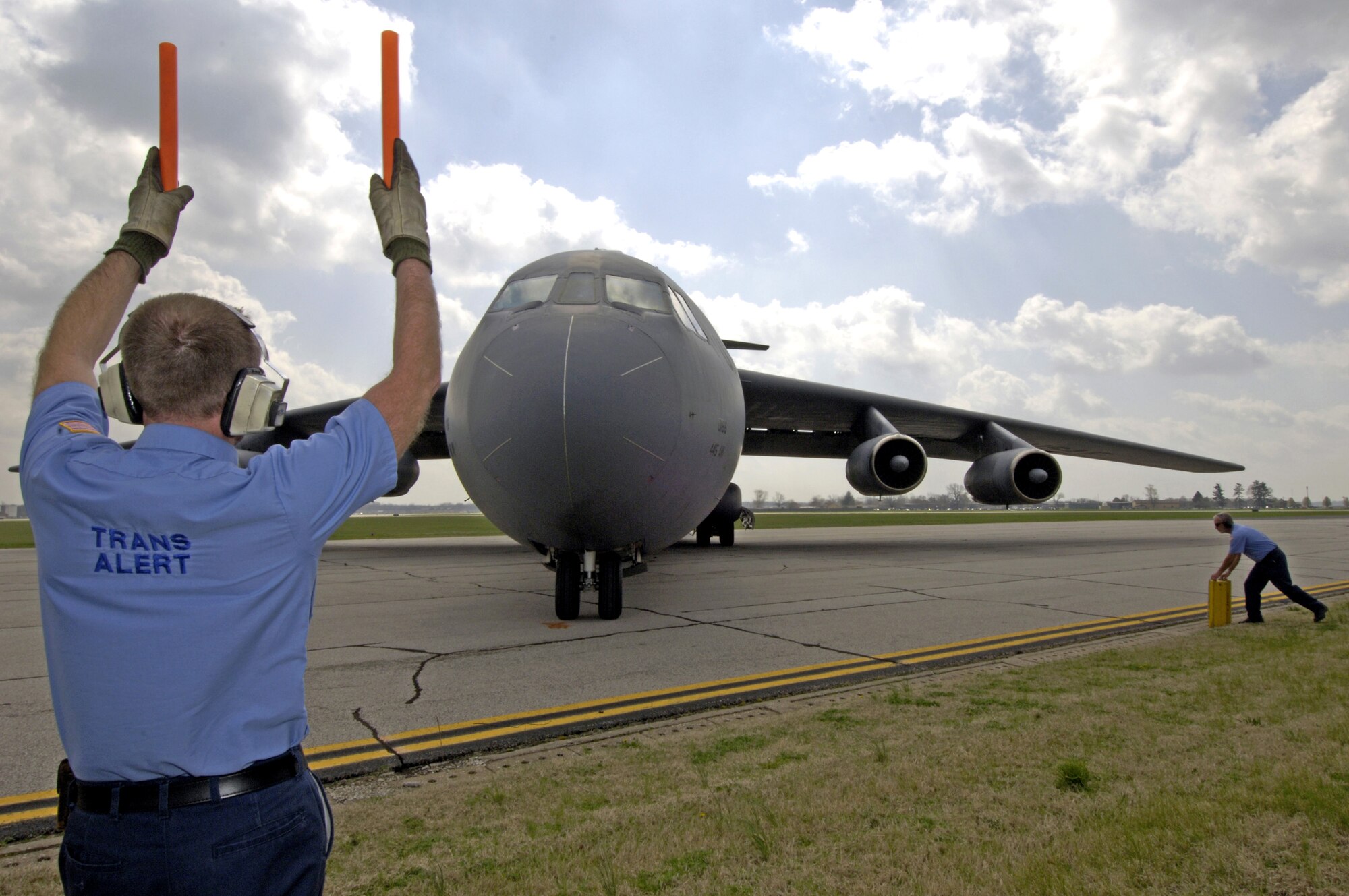 Bill Murphy marshals a C-141C Starlifter from the 445th Airlift Wing on the flightline at Scott Air Force Base, Ill., on Friday, April 7, 2006. The aircraft, tail number 67-0166, made its final flight. It will take its place among other Air Mobility Command aircraft at the heritage airpark being built this year. Mr. Murphy is with the 375th Airlift Wing's transient alert section. The 445th, based at Wright-Patterson Air Force Base, Ohio, is converting from the Starlifter to the C-5 Galaxy. (U.S. Air Force photo/Staff Sgt. Tony R. Tolley)