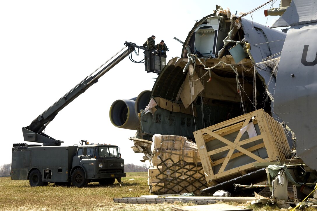 Staff Sgts. John Thomas (left) and Edward Carmack survey the damage as Staff Sgt. Michael Hull moves the truck closer to the wreckage of a C-5 Galaxy that crashed at Dover Air Force Base, Del., on Monday, April 3, 2006. Sergeant Thomas is with the 436th Maintenance Squadron, Sergeant Carmack is with the 512th Aircraft Maintenance Squadron and Sergeant Hull is with the 436th AMXS. (U.S. Air Force photo/Doug Curran) 