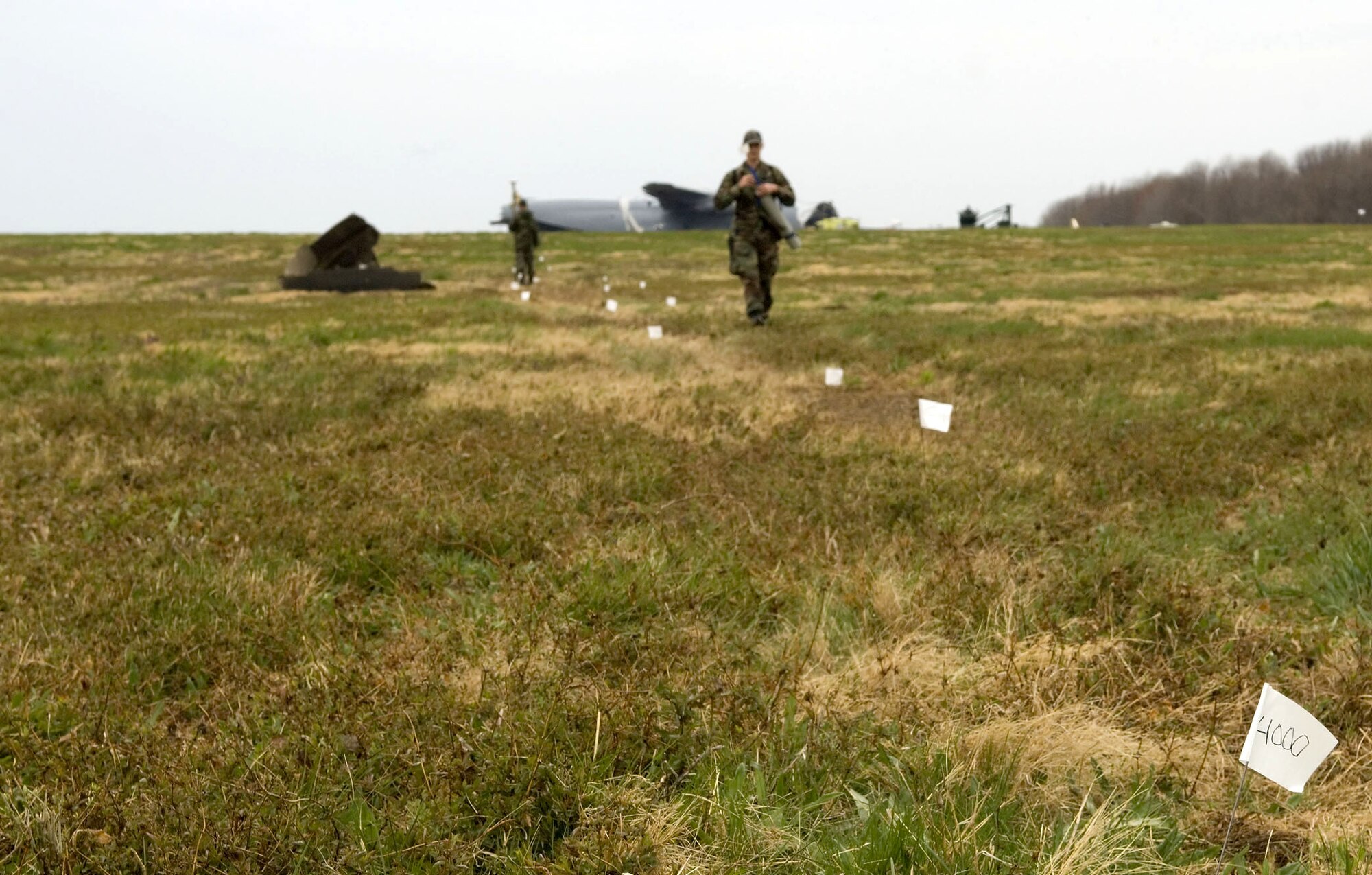 A member of the 436th Civil Engineer Squadron mishap survey team marks debris at Dover Air Force Base, Del., on Friday, April 7, 2006. The C-5 Galaxy in the background crashed at the base April 3. (U.S. Air Force photo/Doug Curran) 
