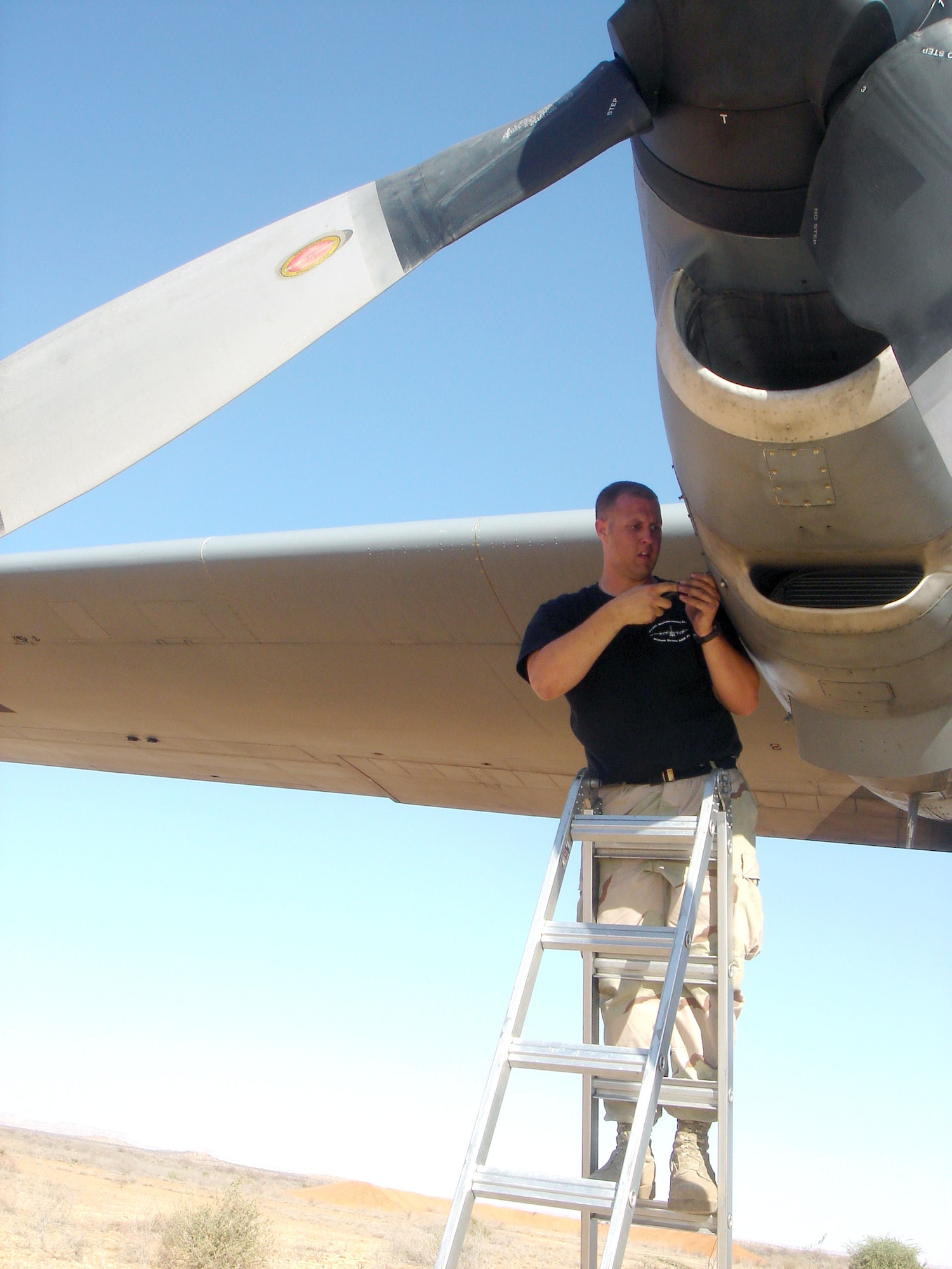 Senior Airman Christopher Sutton removes a panel on a malfunctioning C-130 Hercules engine to determine the problem. Airman Sutton is a crew chief with the 746th Aircraft Maintenance Unit. (U.S. Air Force photo/Maj. Ann P. Knabe) 
