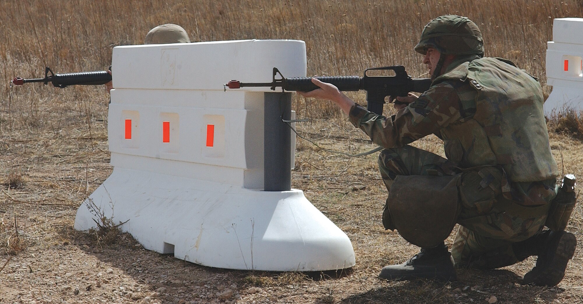 CANNON AIR FORCE BASE, N.M. -- An Airman crouches behind a baricade in the ECS “obstacle course” to avoid enemy weapon rounds or flying debris from explosions.(U.S. Air Force photo by Staff Sgt. April Wickes)