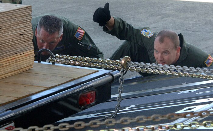 Master Sgt. Shawn Delp (right) and Tech. Sgt. David Benson help unload cargo for a construction project on the Caribbean island of Saint Lucia on Saturday, April 8, 2006, at St. Lucia Airport.  Both are with the 300th Airlift Squadron at Charleston Air Force Base, S.C. (U.S. Air Force photo/Tech. Sgt. Larry A. Simmons) 