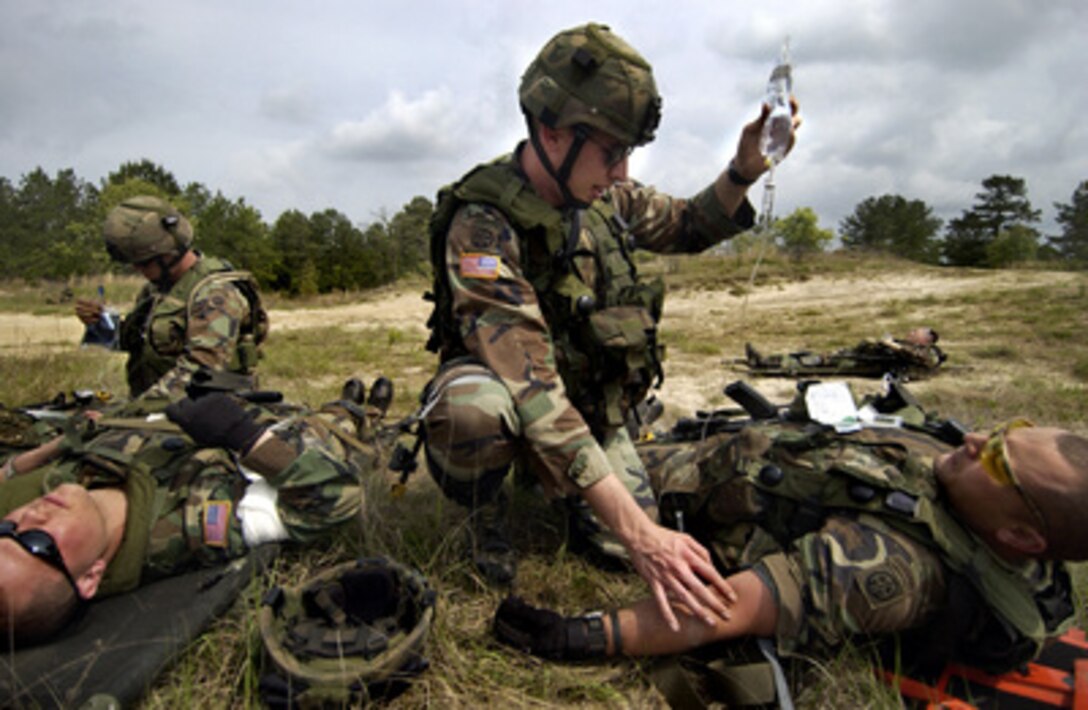 U.S. Army Cpl. Luke Waymon (center) and Spc. Kendal Cryblskey (left) administer IVs to simulated casualties during a cordon and search exercise at the Joint Readiness Training Center, Fort Polk, La., on April 12, 2006. The 14-day field training exercise is designed to prepare the troops for their upcoming deployment to Iraq. Waymon and Cryblskey are combat medics with Headquarters and Headquarters Company, 1st Battalion, 505th Parachute Infantry Regiment, 82nd Airborne Division, Fort Bragg, N.C. 