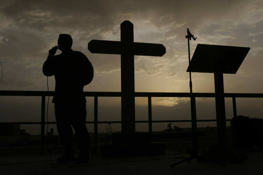 At the cusp of daybreak, Rear Adm. Robert F. Burt, delivers his Easter message to deployed soldiers, sailors, airmen, Marines and civilians who joined him for the Easter sunrise service at Al Asad, Iraq, April 16. Burt is the U.S. Navy Deputy Chief of Chaplains and the Chaplain of the Marine Corps.