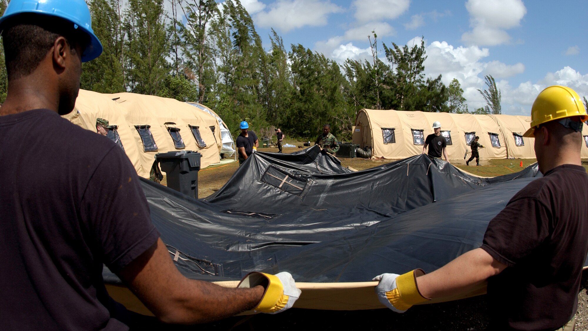 Airmen with the 514th Communications Squadron at McGuire AFB, N.J., set up a tent after heavy rainstorms flooded the location of Exercise Jump Start on Tuesday, April 11, 2006, at Homestead Air Reserve Base, Fla. The communications exercise is designed to familiarize troops from Reserve, Guard and active military units with equipment they wouldn't normally use. Airmen had to rebuild and relocate the tents. (U.S. Air Force photo/Airman 1st Class Bradley Lail)