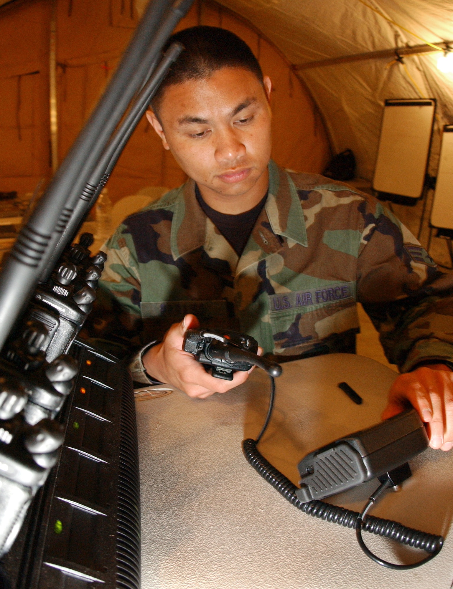 Senior Airman Jason Parasio loads an encryption key for secure communications on land mobile radios, on Monday, April 10, 2006, during Exercise Jump Start at Homestead Air Reserve Base, Fla. The communications exercise is designed to familiarize troops from Reserve, Guard and active military units with equipment they wouldn't normally use. Airman Parasio is a ground radio technician with the 452nd Communications Squadron at March ARB, Calif. (U.S. Air Force photo/Airman 1st Class Bradley Lail)