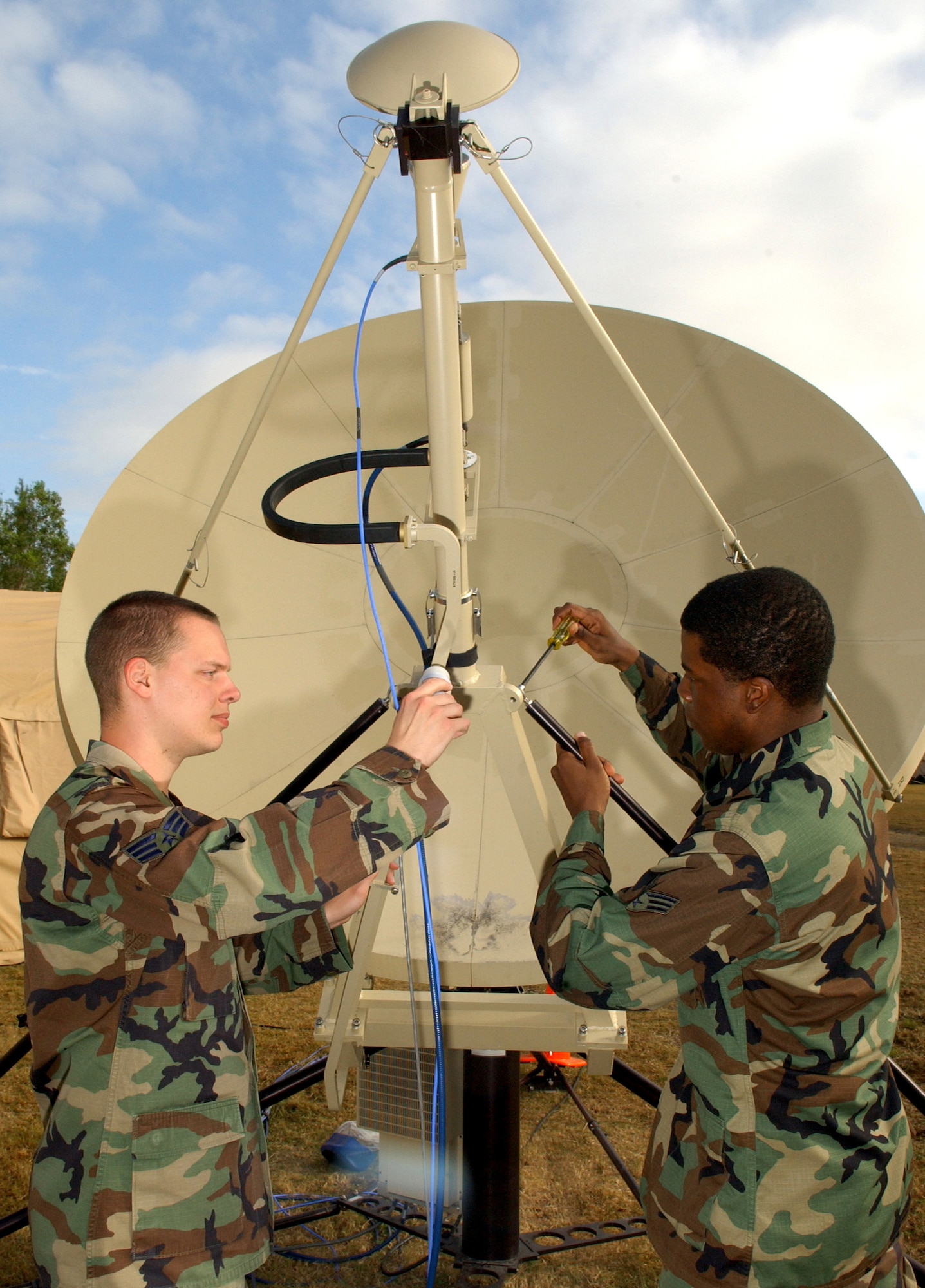 Senior Airmen Michael Mikkelson and Ryan Nicholas adjust the satellite stabilizer  during Exercise Jump Start on Monday, April 10, 2006, at Homestead Air Reserve Base, Fla. The communications exercise is designed to familiarize troops from Reserve, Guard and active military units with communications equipment they wouldn't normally use. Both Airmen are satellite technicians with the 514th Communications Squadron at McGuire Air Force Base, N.J. (U.S. Air Force photo/Airman 1st Class Bradley Lail)