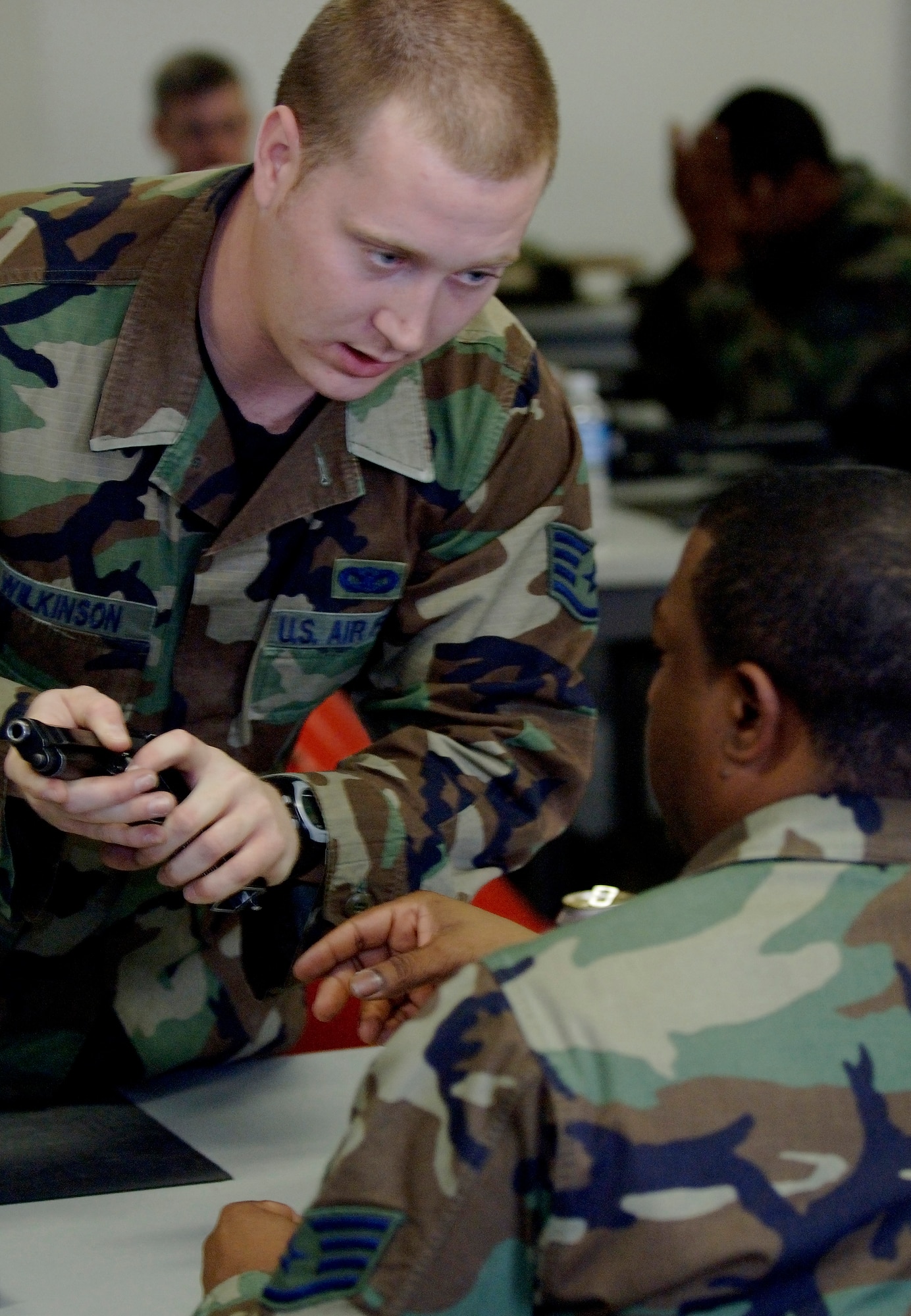 Staff Sgt. Francis Wilkinson, 1st Security Forces Squadron Combat Arms, instructs an M-9 Beretta handgun course in the classroom prior to stepping out to the firing range. Team Langley members train on the M-9 Beretta handgun and the M-4 assault rifle at the Combat Arms Training and Maintenance (CATM) course on Dec. 14, 2005 at Langley Air Force Base, Virginia. (U.S. Air Force photo by Staff Sgt. Verlin Levi Collins)