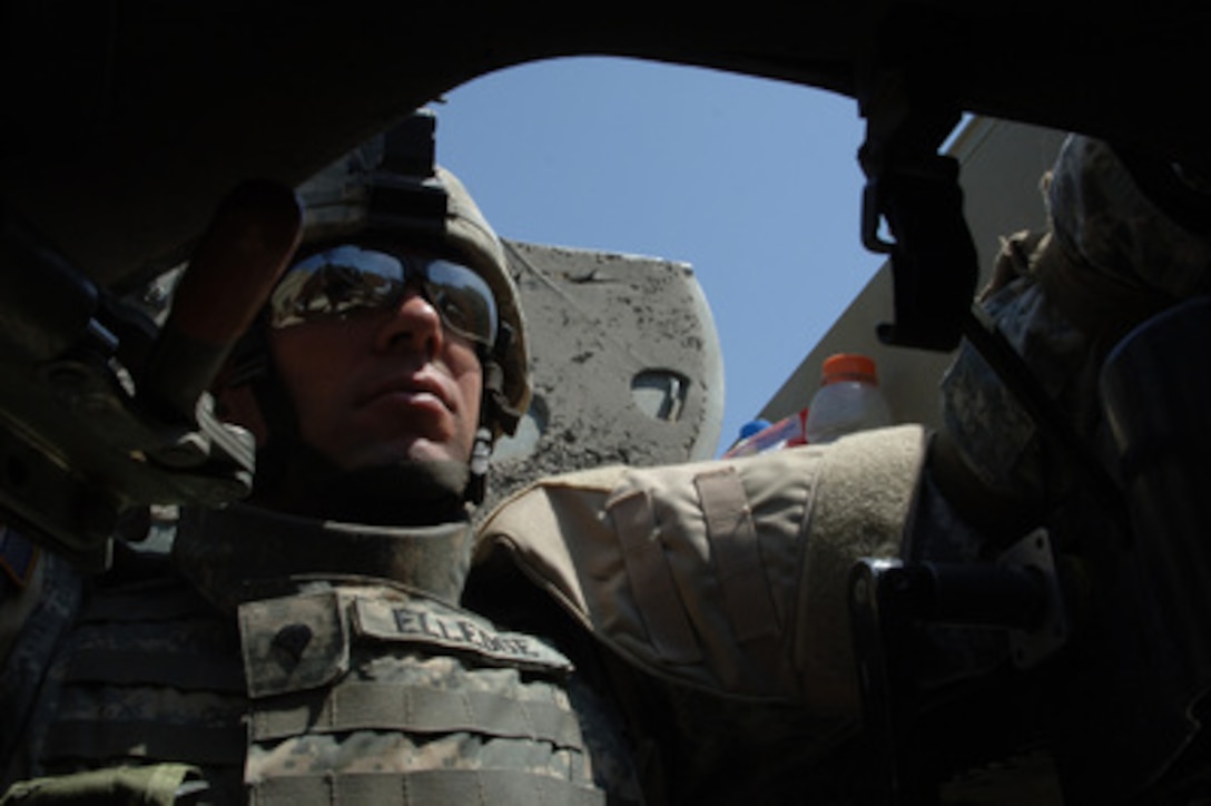 U.S. Army Spc. Michael Elledge sits in the turret of a .50 caliber machine gun he is using to provide security for a convoy during operations in Baqubah, Iraq, on April 10, 2006. Elledge is assigned to the 1st Battalion, 68th Armor Regiment, 4th Infantry Division. 
