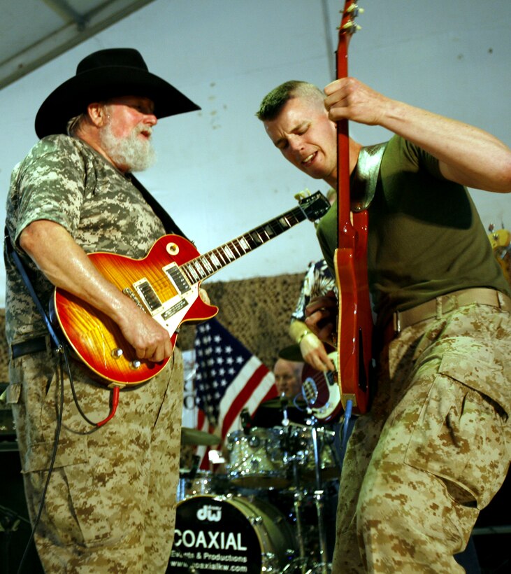 Marine Cpl. Steven D. Cord rocks out on guitar with music legend Charlie Daniels during a concert at Camp Taqaddum, Iraq April 16, 2006.  Steven and his brother, Timothy, also a Marine corporal, opened for the Charlie Daniels Band and were later invited on stage to perform with the band in front of nearly 1,500 service members stationed here in western Iraq.
