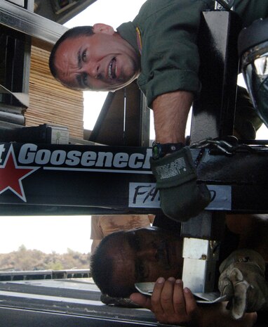 Tech. Sgt. Mike Smith (top) and Senior Master Sgt. Jesus Suniga position a trailer to be loaded at a Saint Lucia airport for a return flight Sunday, April 9, 2006. The aircrew delivered construction materials and Reserve civil engineers who are building an operations center and barracks for the police force in support of Saint Lucia's counter-drug operations. Sergeant Smith is a loadmaster with the 300th Airlift Squadron at Charleston Air Force Base, S.C., and Sergeant Suniga is with the 433rd Civil Engineer Squadron at Lackland AFB, Texas. (U.S. Air Force photo/Tech. Sgt. Larry A. Simmons)