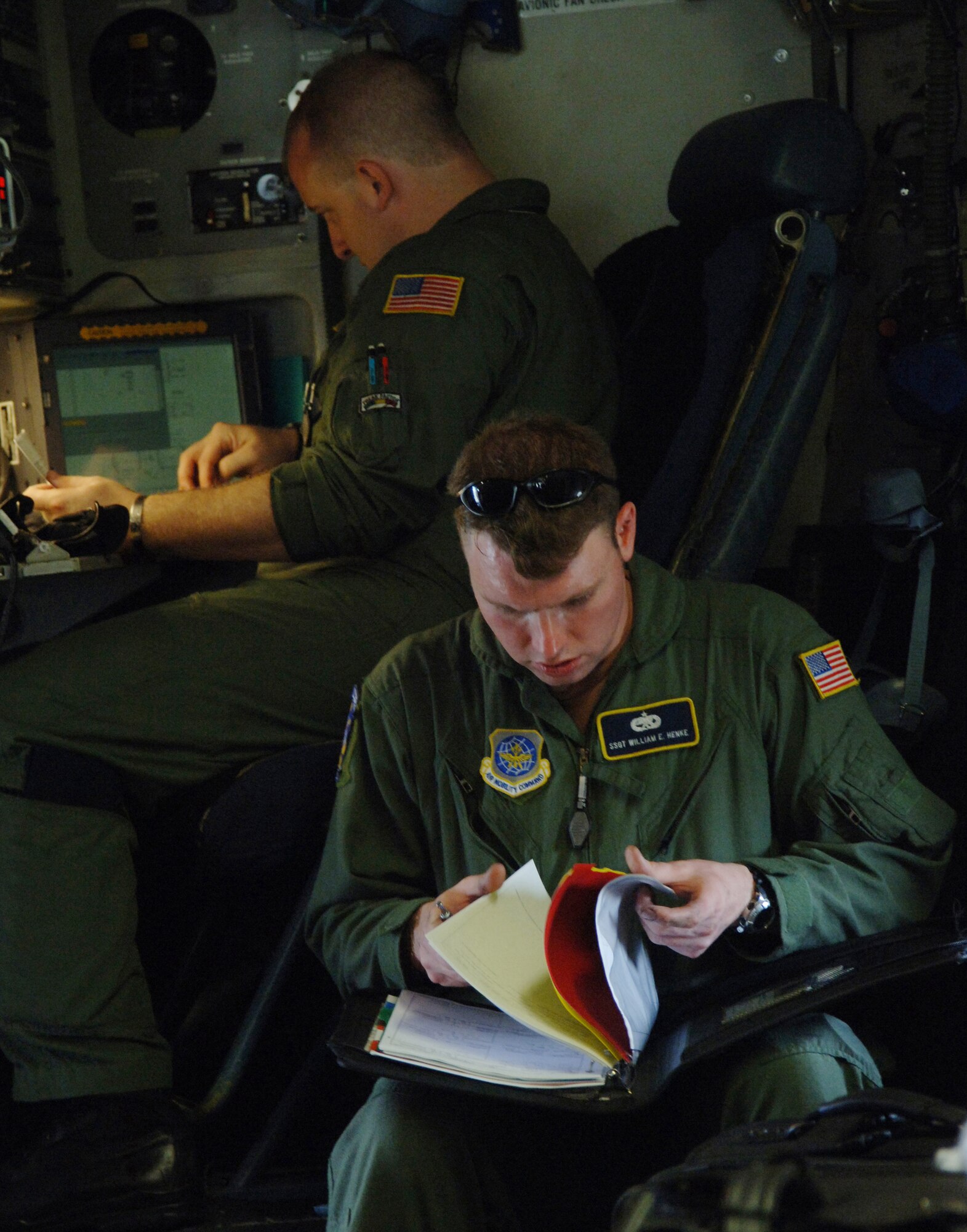 Staff Sgts. William Henke (front) and J.J. Hoffman check C-17 Globemaster III maintenance forms and weights and balances before takeoff from a Saint Lucia airport on Sunday, April 9, 2006. The crew transported Reserve civil engineers who are building an operations center and barracks for the police force in support of Saint Lucia's counter-drug operations. Sergeant Hoffman is a loadmaster with the 300th Airlift Squadron and Sergeant Henke is a flying crew chief with the 437th Aircraft Maintenance Squadron. Both units are out of Charleston Air Force Base, S.C. (U.S. Air Force photo/Tech. Sgt. Larry A. Simmons)