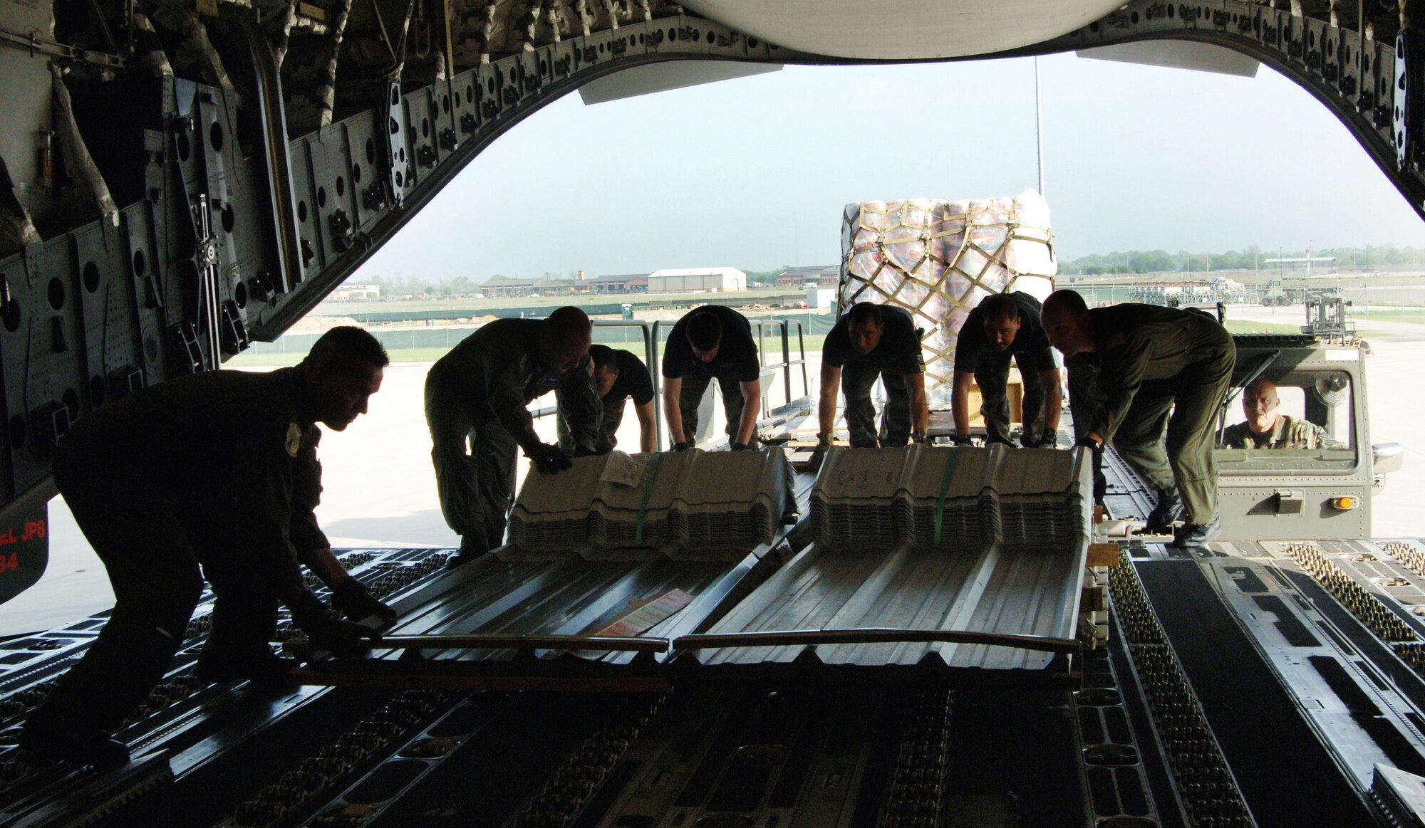 Airmen from the 300th Airlift Squadron at Charleston Air Force Base, S.C., and the 433rd Civil Engineer Squadron at Lackland AFB, Texas, load cargo for transport to Saint Lucia Friday, April 7, 2006. The aircrew was delivering construction materials and Reserve civil engineers who are building an operations center and barracks for the police force in support of Saint Lucia's counter-drug operations. (U.S. Air Force photo/Tech. Sgt. Larry A. Simmons)
