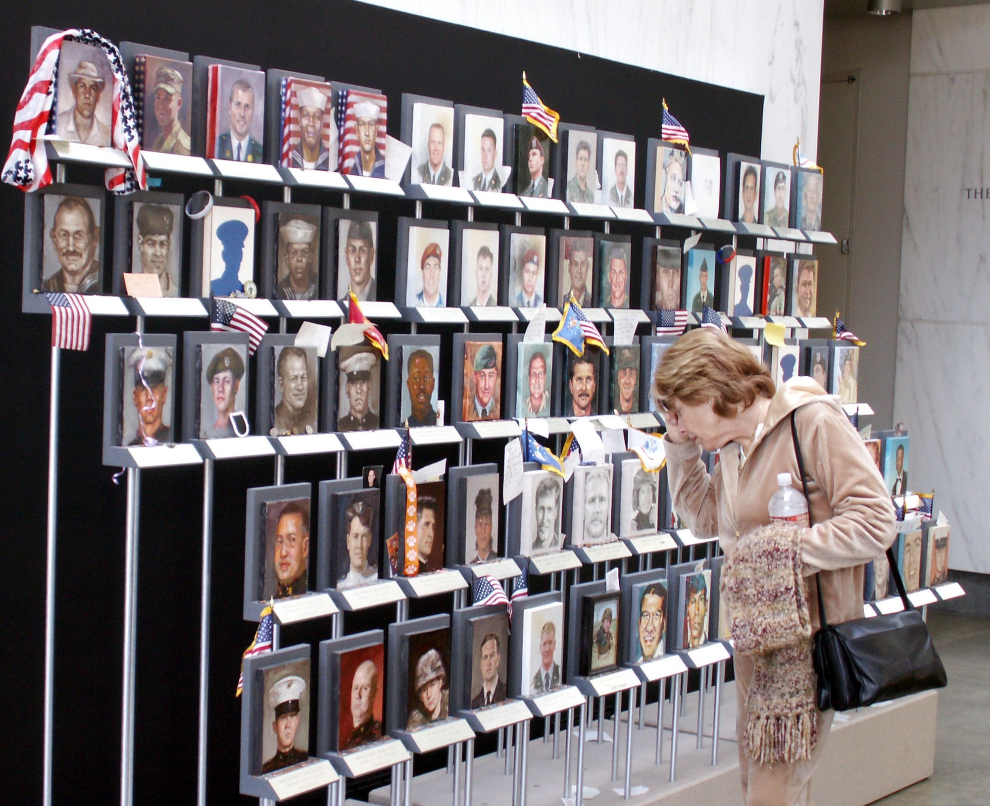 Sandra Henriks of Woodland Hill, Calif., stops to read some notes left at the "Faces of the Fallen" portrait gallery at the Women in Military Service to America Memorial in Arlington, Va. (American Forces Press Service photo/Rudi Williams)
