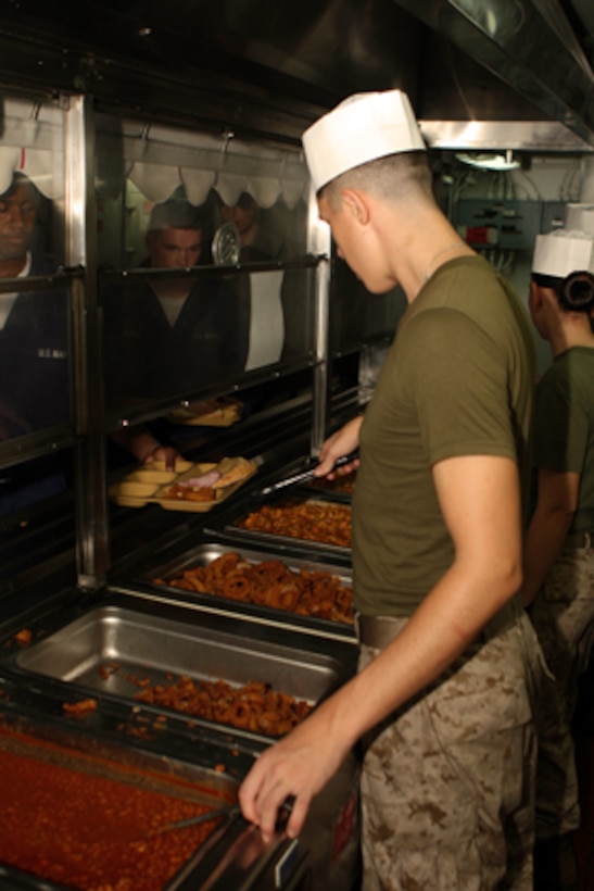 Lance Cpl. Steven W. Daust, motor transportation operator, India Battery, Battalion Landing Team 2/5, 15th Marine Expeditionary Unit serves lunch to Marines of the 15th MEU and the crew of USS Peleliu in the galley of the enlisted mess deck aboard ship.::r::::n::   The Marines and Sailors who make the mess decks run smoothly are the mess-men who prepare and serve nearly 2,400 trays per meal 4-times a day. ::r::::n::    On average, the mess-men use over 1,000 pounds of meat or poultry per meal and over a ton of fruits and vegetables per day.::r::::n::    Mess duty consists of 30 12-hour days on one of USS Peleliu's three mess decks. Mess-men help prepare, serve and store food aboard USS Peleliu as well as keeping the mess decks clean.::r::::n::   The Camp Pendleton, Calif. based 15th MEU is comprised of approximately 2,200 Marines and Sailors and is a forward deployed force of readiness capable of conducting numerous operations, such as Non-Combatant Evacuation Operations, Humanitarian Assistance Operations and a wide range of amphibious missions. The 15th MEU is currently deployed aboard the USS PELELIU (LHA-5), USS DUBUQUE (LPD-8) and USS PEARL HARBOR (LSD-52). (Official US Marine Corps photo by Lance Cpl Timothy T. Parish) (Released)