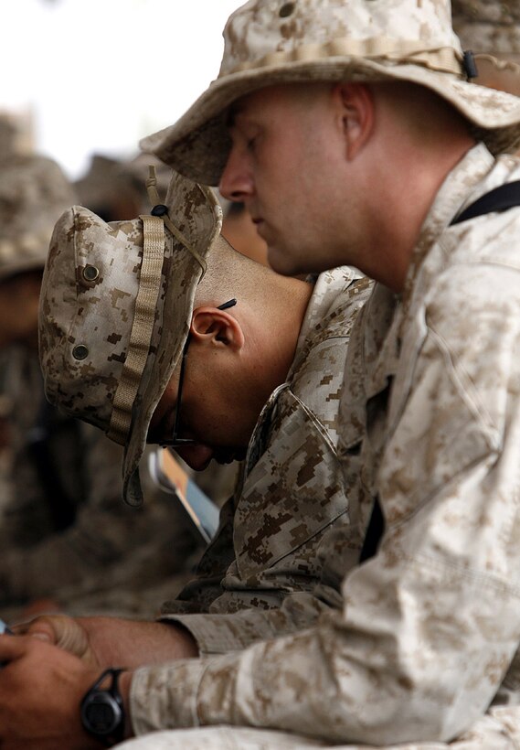 Hundreds of U.S. Marines, sailors, soldiers and civilians, like Cpl. Ron E. Beavor, 25, of Lawton, Okla., and Lance Cpl. Robert Snyder, 21, of Temecula, Calif., attended an April 18, 2006, memorial service at Camp Al Asad, Iraq, for six Marines and one sailor who died earlier this month in a vehicle accident in while serving in western Al Anbar Province, Iraq. All seven fallen Marines and sailor were part of the Camp Pendleton, Calif.-based 1st Marine Logistics Group. All seven died when their seven-ton truck, part of a Marine combat logistics re-supply in Iraqâ??s Al Anbar Province, rolled over during a flash-flood April 2. A memorial service for an eighth Marine, who was with the Hawaii-based 3rd Battalion, 3rd Marine Regiment and was killed in the same accident, was held at the Marinesâ?? base in Haditha last week. Attached to CLB-7â??s Engineering Company, Beavor is a motor transportation operator, while Snyder is a vehicle mechanic. One of the seven deceased U.S. servicemembers, Lance Cpl. Brian R. St. Germain, was attached to Engineering Company. (Photo by Staff Sgt. Jim Goodwin)::n::