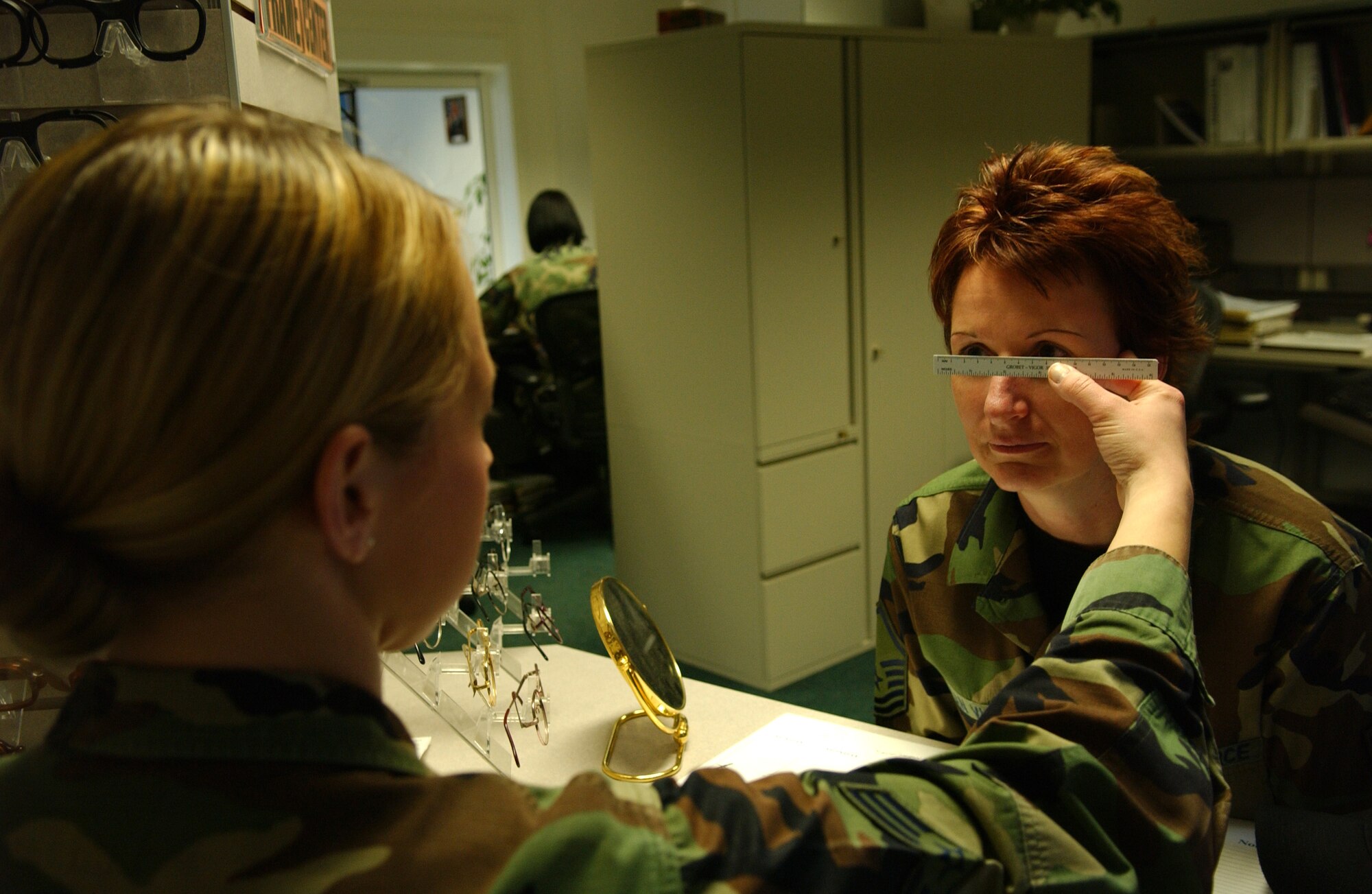 Senior Airman Holly Klug measures the diameter of Master Sgt. Carrie VanVlack's eyes for a new pair of glasses. Sergeant VanVlack is assigned to the 435th Logistics Readiness Squadron at Ramstein Air Base, Germany. Airman Klug is an optometry technician with the 435th Aerospace Medicine Squadron. (U.S. Air Force photo/Airman Julianne Trulson)