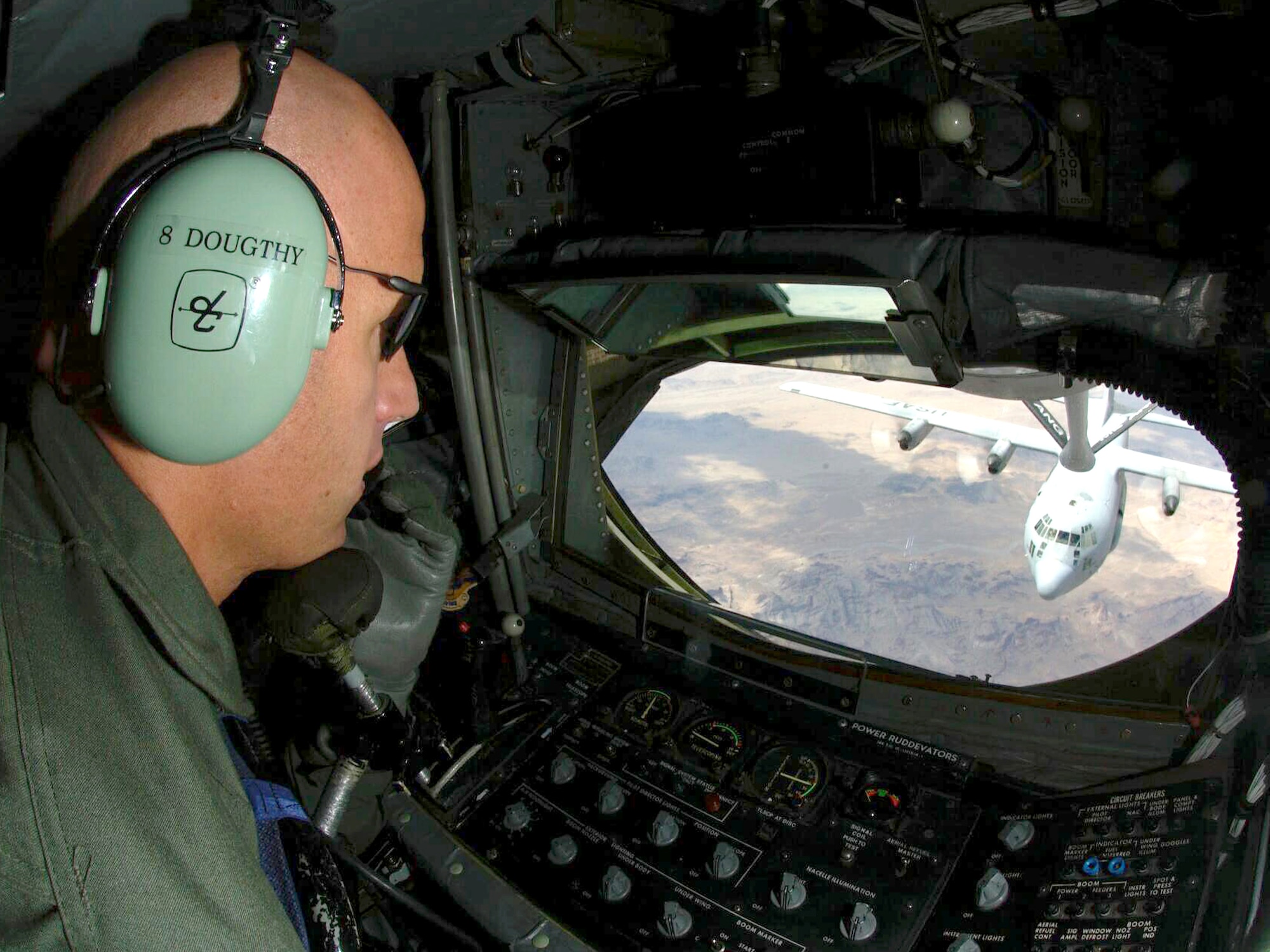Staff Sgt. Mark Dougthy coordinates positioning of a KC-135E Stratotanker with a C-130 Hercules while he operates the boom during an air refueling Friday, April 14, 2006, over Tucson, Ariz. Sergeant Dougthy and the KC-135E are from the Air National Guard's 101st Air Refueling Wing at Bangor, Maine. The C-130 is assigned to the 42nd Electronic Combat Squadron at Davis-Monthan Air Force Base, Ariz. (U.S. Air Force photo/Senior Airman Christina D. Ponte)
