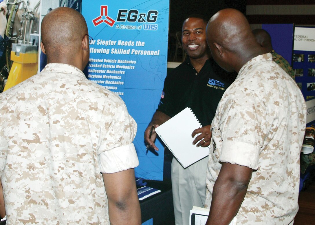 Harold Holden, a recruiter for Aerospace Technical Services Group and a retired master sergeant, talks to a group of Marines Tuesday at the Career and Education Fair that was held in the Depot's Lyceum.  The fair featured 98 booths ranging from NASCAR to the Savannah College of Art and Design.