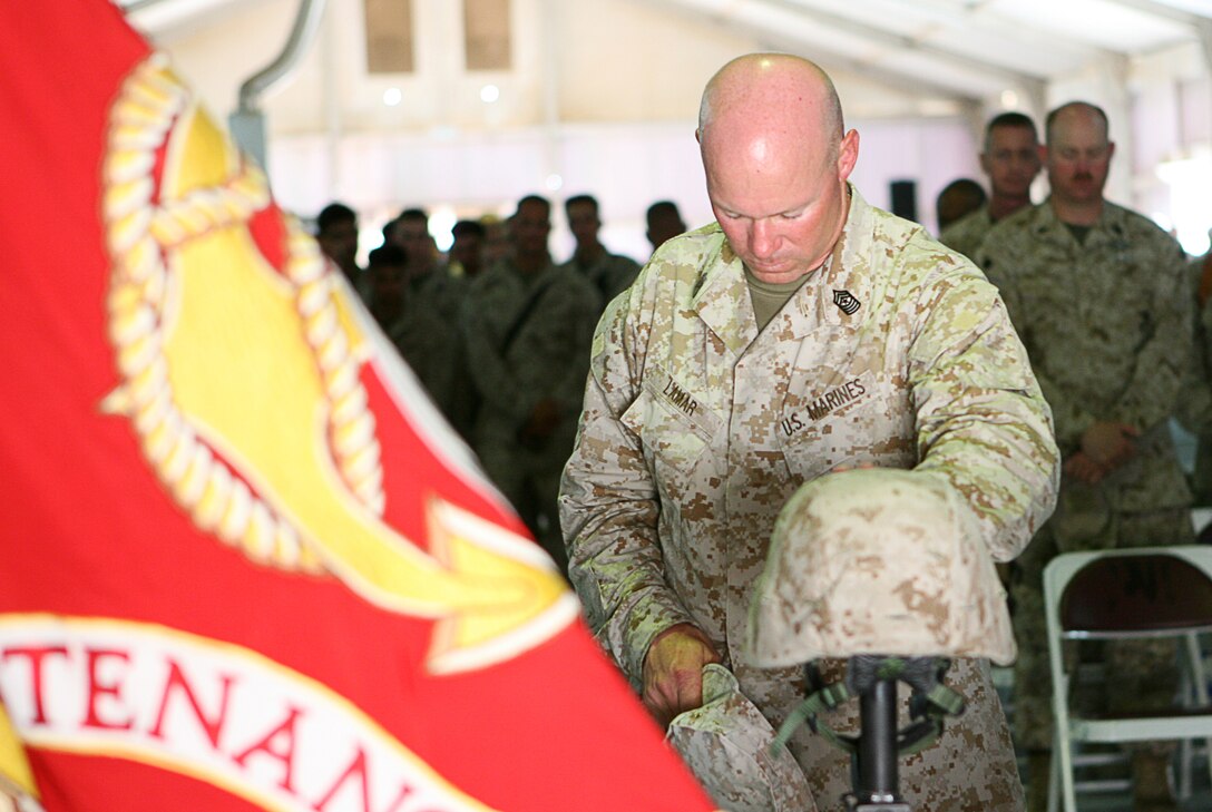 Pausing to reflect, Sgt. Maj. Timothy P. Lamar, sergeant major for Combat Logistics Regiment 15, mourns the loss of one of his own at a memorial service held here April 19, 2006 for Lance Cpl. Darin T. Settle. A native of Henley, Mo., Settle, 23, died April 14 from injuries sustained in a non-hostile motor vehicle accident in Al Anbar Province, Iraq. He was deployed here as a machine gunner with Transportation Support Company, CLR- 15. Following remarks by Settleâ??s friends and coworkers, a 21-gun salute was fired to honor the fallen Marine who was serving his second tour of duty in Iraq. Settle is survived by his son, Wesley Arvin Gage Settle and his parents, James and Ruby Settle.