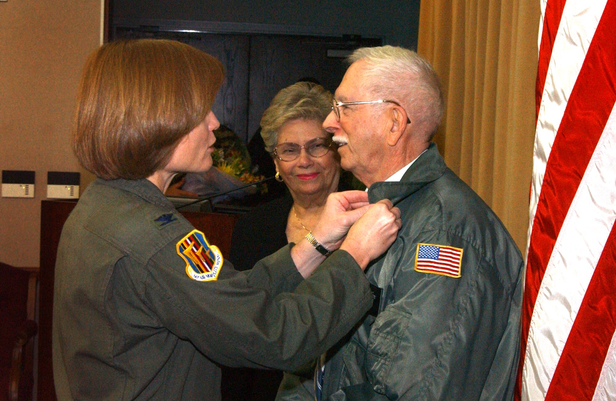 Col. Lyn Sherlock, 60th Air Mobility Wing commander, gives Mr. Robert Andrews, 60th Comptroller Squadron, a pin recognizing his 50 years of federal service. (U.S. Air Force photo by Nan Wylie)