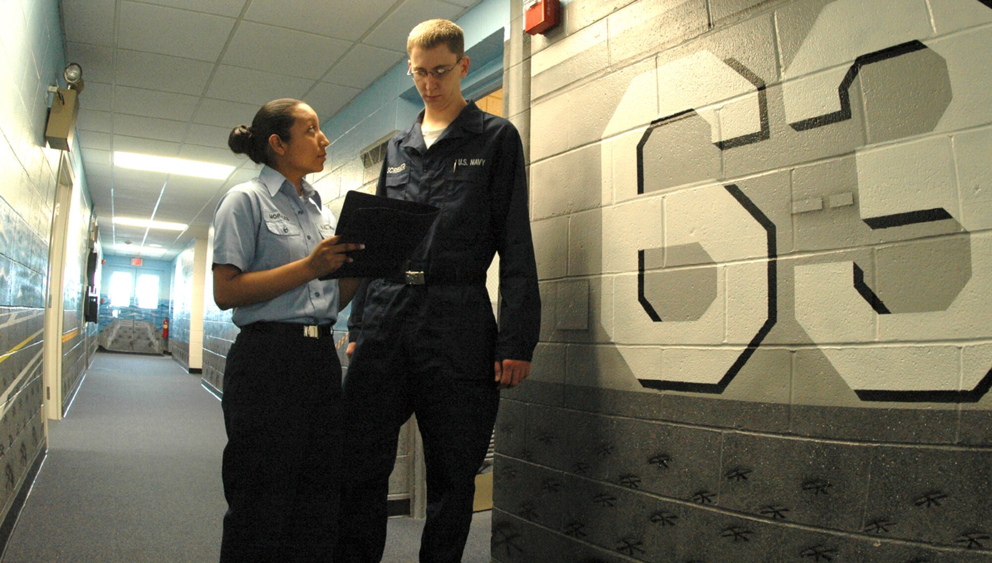 Seaman Elizabeth Morales, administrative technician, discusses personnel issues with Seaman Evan Scribner, aircraft maintenance technician.  The detachment maintains a full-time staff including administrative, maintenance and communications members.  Aircrew members rotate in and out with mission requirements. (U.S. Air Force photo by Staff Sgt. Raymond Hoy)

