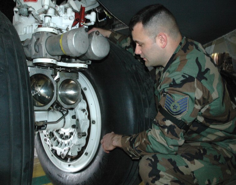 Tech Sgt. James Mazurek, 5th Maintenance Squadron, shows where a tow bar hooking up to the main landing gear of a B-52H Stratofortress can cause damage. (U.S. Air Force photo by Senior Airman Danny Monahan)