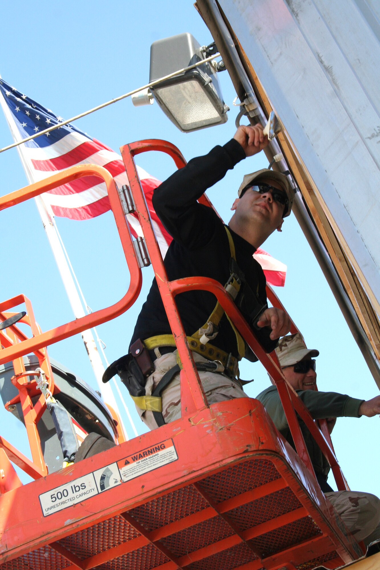 Staff Sgt. Josh Flaherty and Tech. Sgt. Thomas Nevins weatherproof panelling on the newly renovated wing headquarters at Manas Air Base, Kyrgyzstan. Every last detail was completed in-house. (U.S. Air Force photo/Staff Sgt. Lara Gale)
