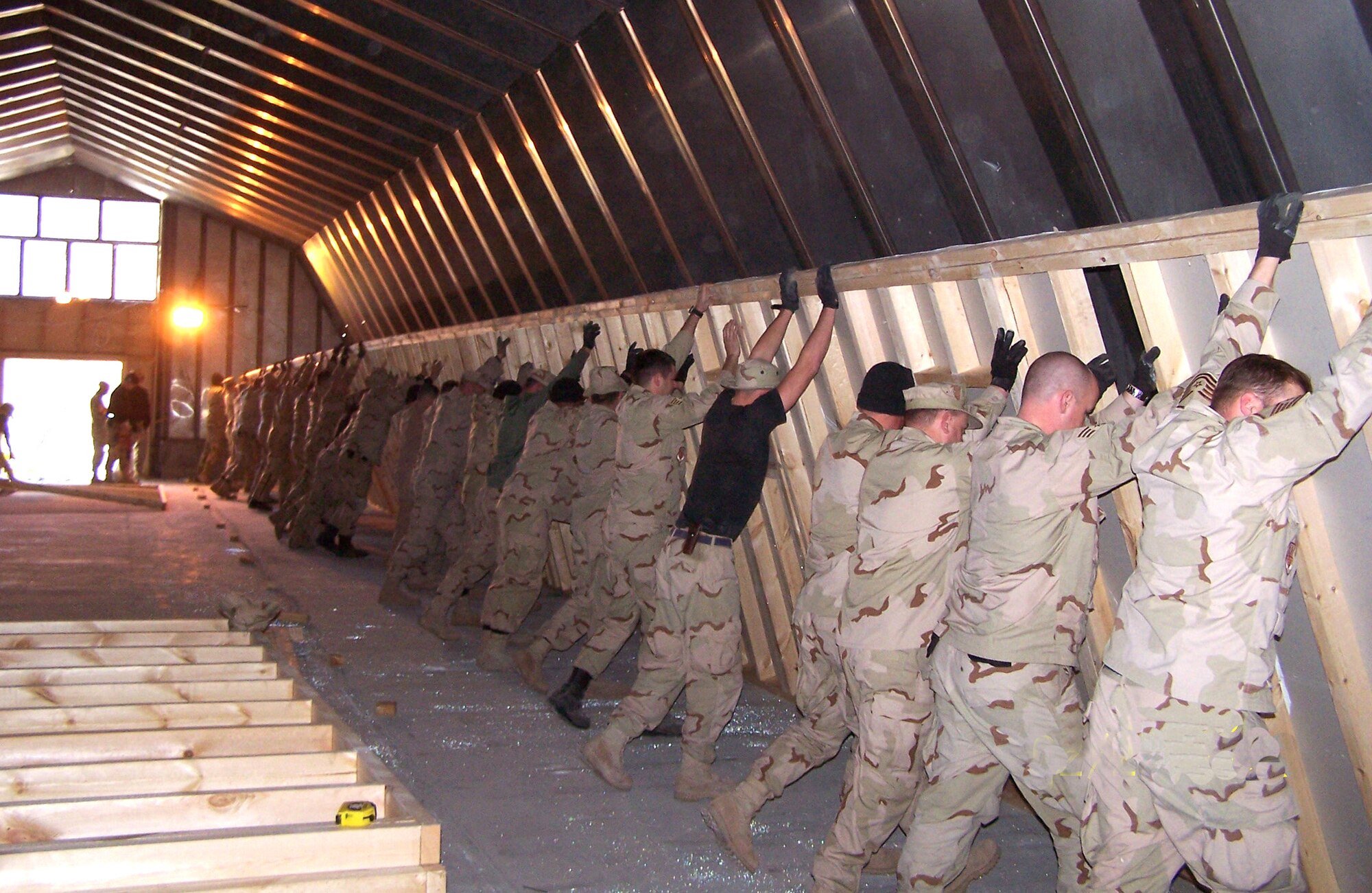Troops from every shop in the 376th Expeditionary Civil Engineer Squadron came together to raise the first bearing wall for the newly renovated wing headquarters building in mid-February at Manas Air Base, Kyrgyzstan. By keeping the project in-house, the base saved $525,000. (U.S. Air Force photo/Master Sgt. Roger Williams)
