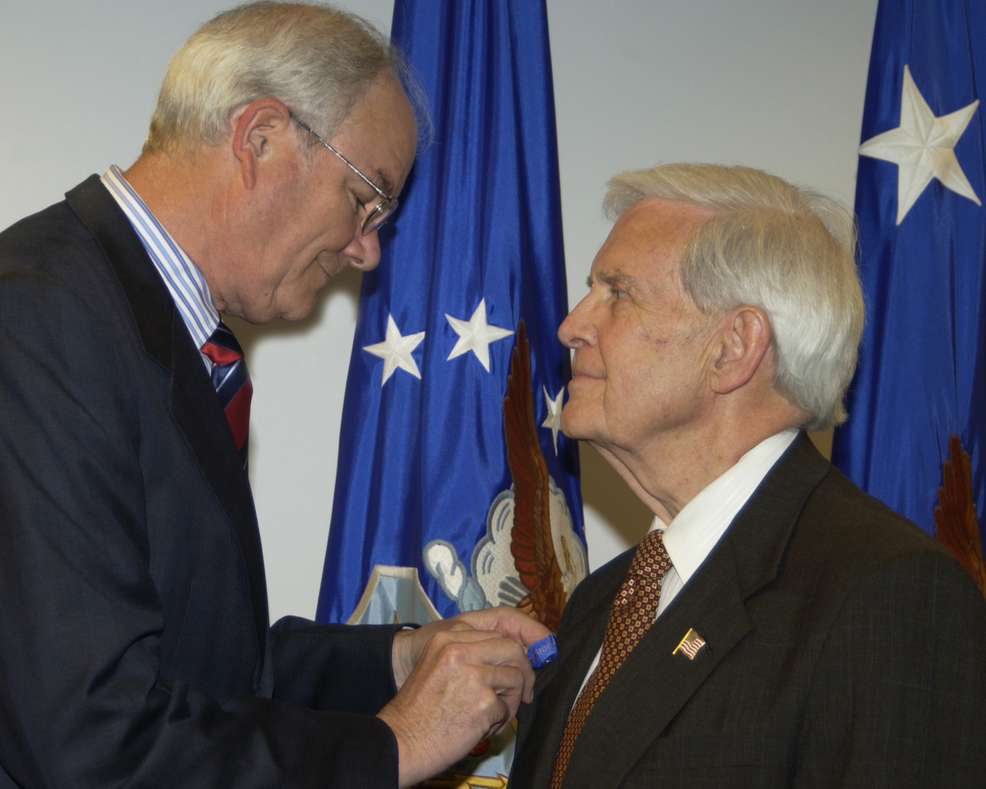 Secretary of the Air Force Michael W. Wynne presents Ron Hall, a civilian Air Force photographer at the Pentagon, with an exceptional civilian service award for his 50 years of service to the Air Force. (U.S. Air Force photo/Mickey Sanborn) 

