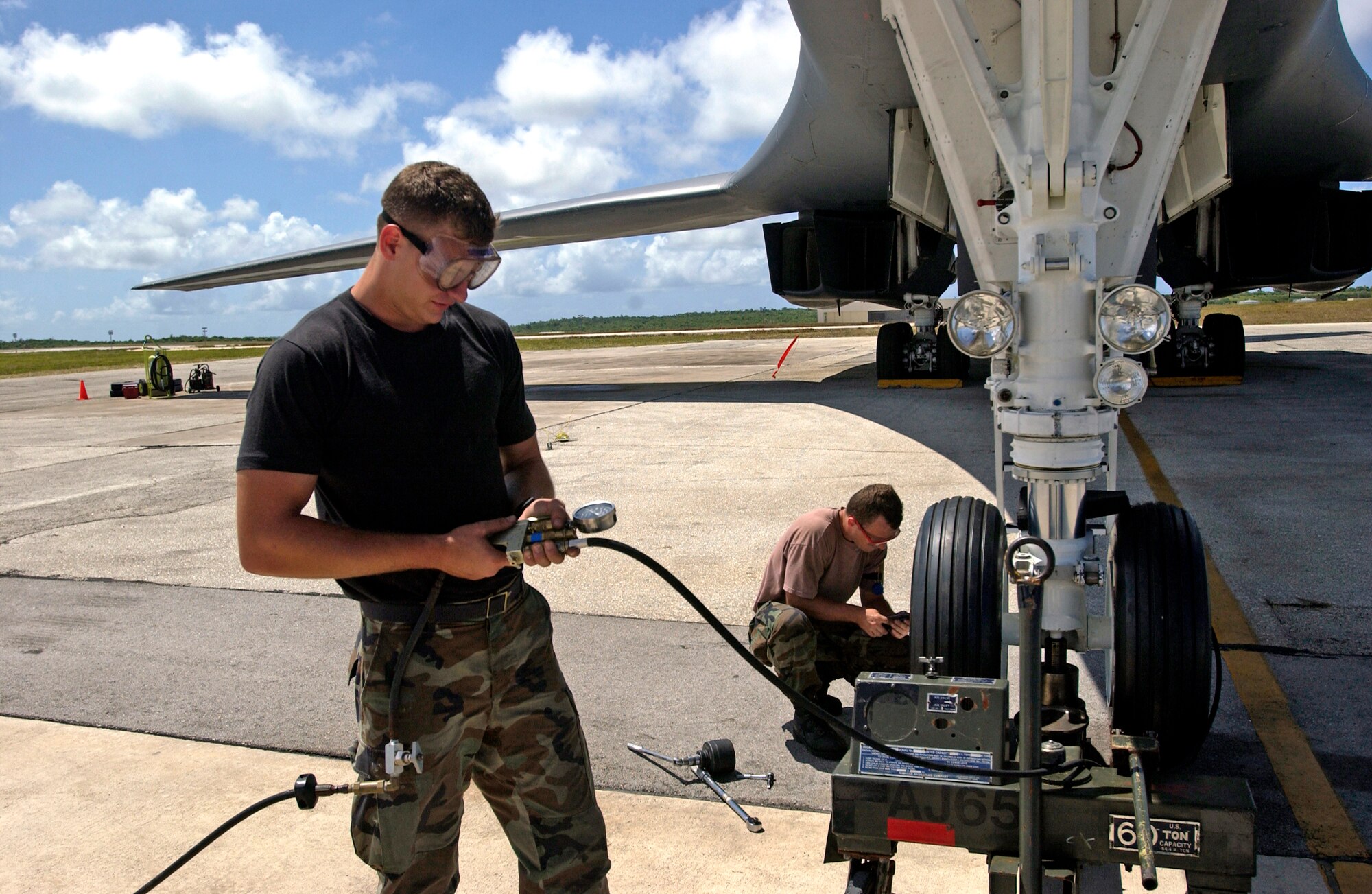 Senior Airman Alex Berger inflates a recently installed nose landing-gear tire on a B-1B Lancer while Senior Airman Thomas Feenstra prepares to replace the other one Monday, April 17, 2006, at Andersen Air Force Base, Guam. The Airmen are assigned to the 36th Expeditionary Aircraft Maintenance Squadron. (U.S. Air Force photo/Airman 1st Class Michael Dorus)