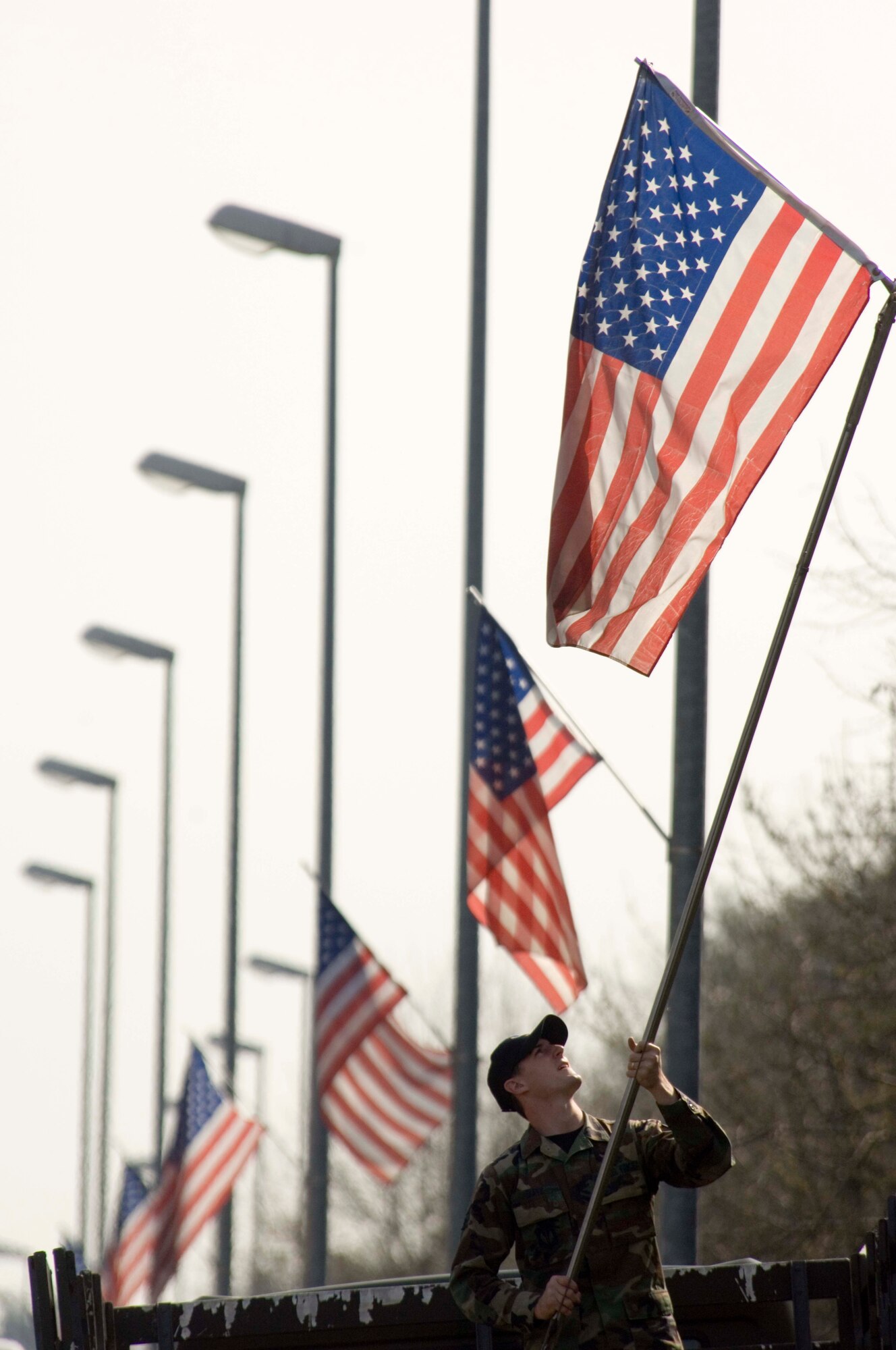 Senior Airman Shawn Duffy posts a new flag on the main drive at Ramstein Air Base, Germany, on Wednesday, April 19, 2006. Officials replace older flags periodically as part of the installation excellence program. Airman Duffy is a land and mobile radio technician with the 435th Communication Squadron. (U.S. Air Force photo/Master Sgt. John E. Lasky)