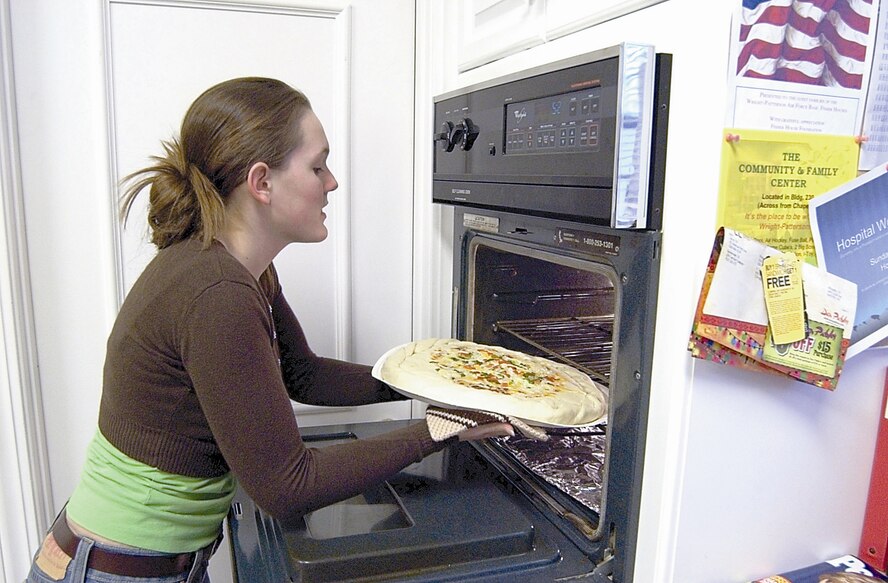 WRIGHT-PATTERSON AIR FORCE BASE, Ohio - Jenna Bullock prepares to heat up a pizza for guests at the Fisher House. A Beavercreek High School junior, Jenna and her mother, Paula, cook meals and host bingo games twice a month at the house to distract patients and their families for a time from their problems. (Air Force photo by Spencer P. Lane)


