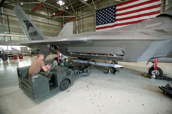 Senior Airman Daniel Myers and Staff Sgts. Daphne Jaehn and John Davenport load an AIM-120D Advanced Medium Range Air-to-Air Missile on an F-22A Raptor in preparation for noise and vibration testing at Edwards Air Force Base, Calif. The Airmen are assigned to the base's 412th Aircraft Maintenance Squadron and are with the F-22 Combined Test Force weapons flight. (U.S. Air Force photo/Kevin Robertson)