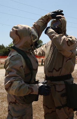 Staff Sgt. Timothy Mueller pats down Maj. Mike Arnold, both from the 16th Special Operations Squadron, with simulated decontamination paper at the permanent exercise facility Wednesday during the Ability to Survive and Operate Rodeo. (Photograph by A1C Ali Flisek)