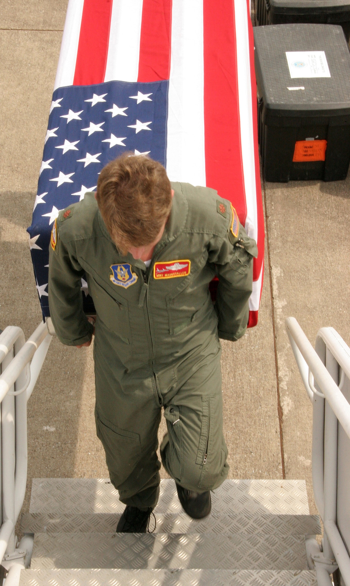 Maj. Mike Markstaller carries a flag-draped transfer case containing remains believed to be of a U.S. serviceman killed in Vietnam. Major Marksteller, a pilot with the 939th Air Refueling Wing, and seven other Airmen from 939th ARW transported the remains from Thailand to Hickam Air Force Base, Hawaii, Tuesday, April 18, 2006. Scientists will now analyze the remains in hopes of positively identifying the servicemember. (U.S. Air Force photo/Maj. James R. Wilson)