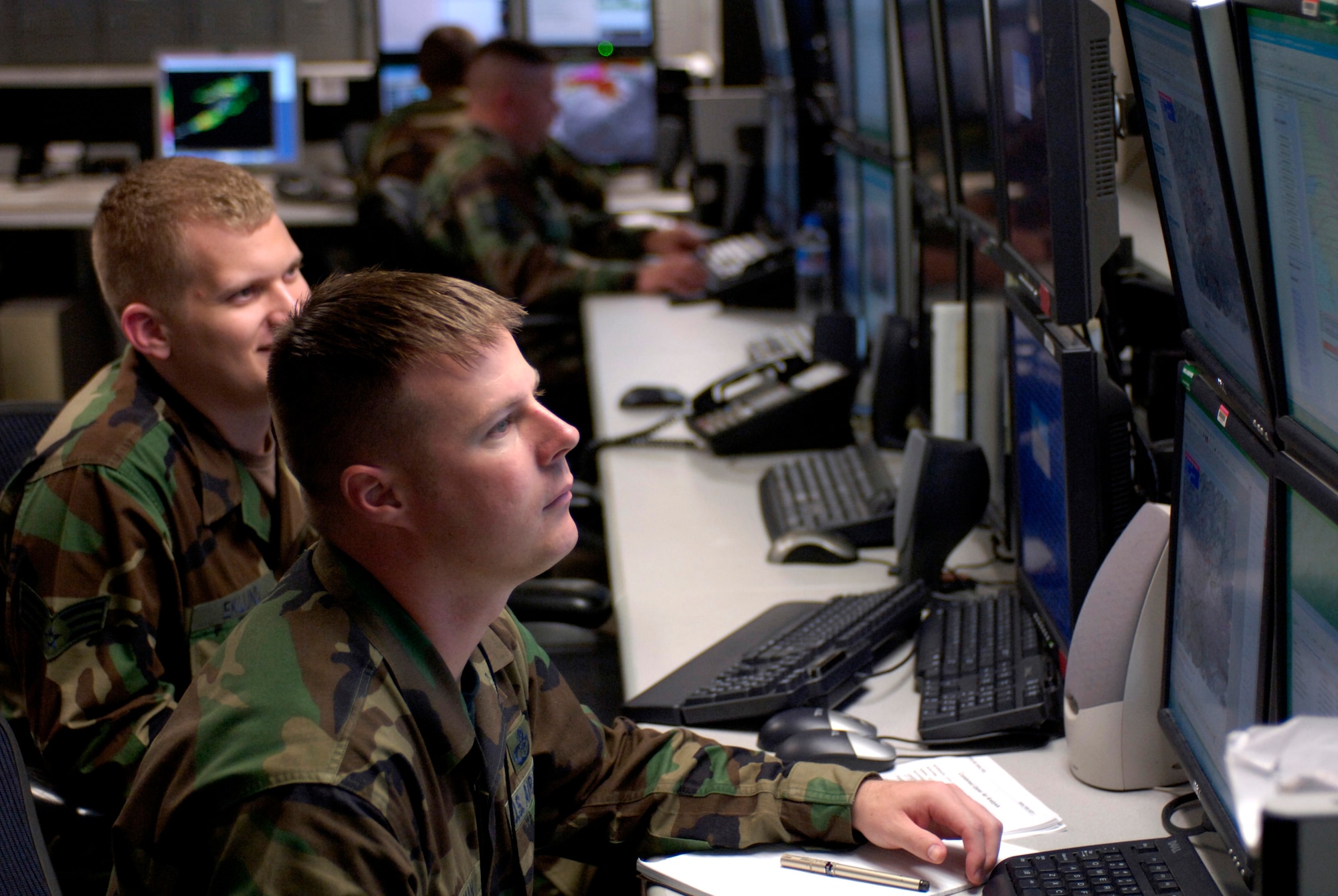 Master Sgt. Charles Hoffman and Senior Airman Christopher Eklund collaborate and discuss weather forecasts for Korea and Japan on the operations floor Tuesday, April 18, 2006, at Hickam Air Force Base, Hawaii. Sergeant Hoffman and Airman Eklund are with the 17th Operational Weather Squadron, which provides Pacific Air Forces with tailored operational forecasts. (U.S. Air Force photo/Tech. Sgt. Shane A. Cuomo) 