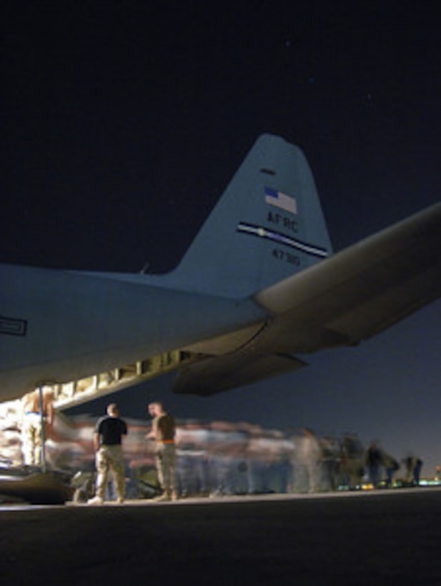 The line of passengers becomes a blur as they board a U.S. Air Force Reserve C-130H Hercules aircraft for a flight from Sather Air Base, Iraq, on April 20, 2006. The Hercules and its crew are attached to the 302nd Airlift Wing, Peterson Air Force Base, Co. 