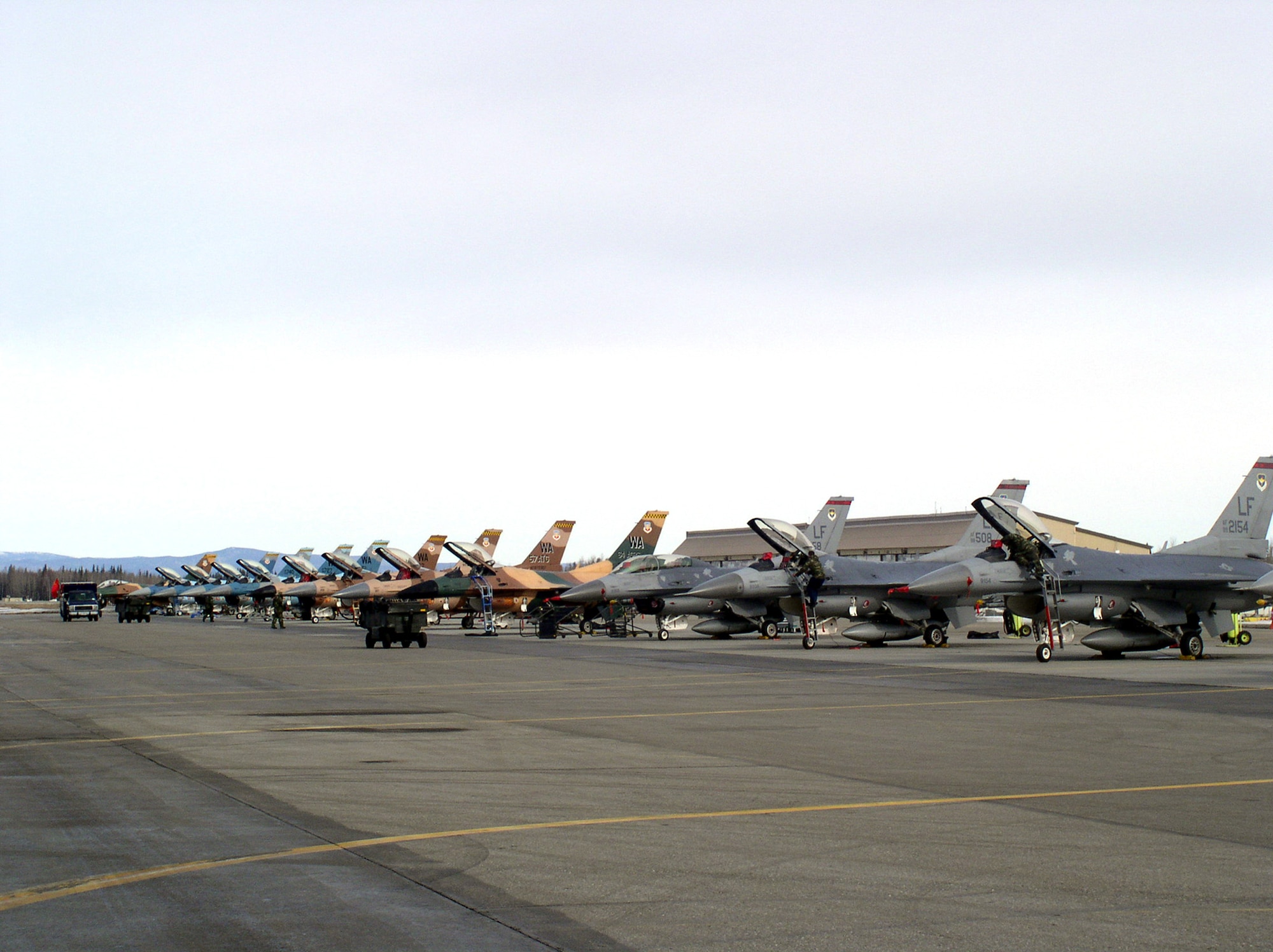 F-16 Fighting Falcons from the 63rd Fighter Squadron at Luke Air Force Base, Ariz., and the 64th Aggressor Squadron at Nellis AFB, Nev., line the flightline at Eielson AFB, Alaska, for Red Flag-Alaska 06-2. The exercise, previously called Cope Thunder, was enhanced to provide training on the same level as the Red Flag exercise at Nellis. (U.S. Air Force photo/Tech. Sgt. Sara Hilmoe)
