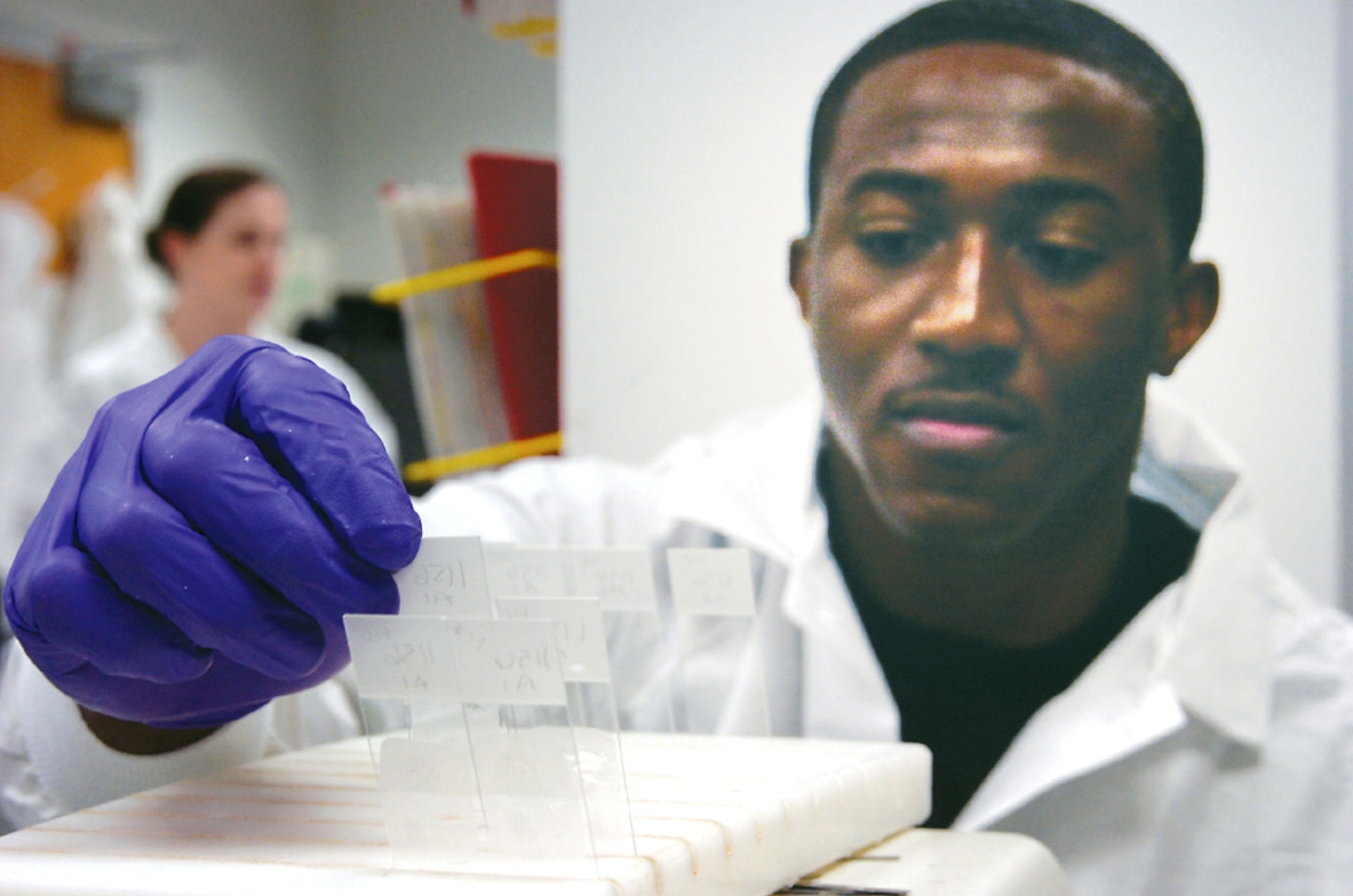 Airman 1st Class Michael Newford catalogs breast tissue specimens in a slide tray holder. The specimens will later be diagnosed by a pathologist. Airman Newford is one of seven histopathology technicians at the 89th Medical Support Squadron pathology department at Andrews Air Force Base, Md. (U.S. Air Force photo/Bobby Jones)
