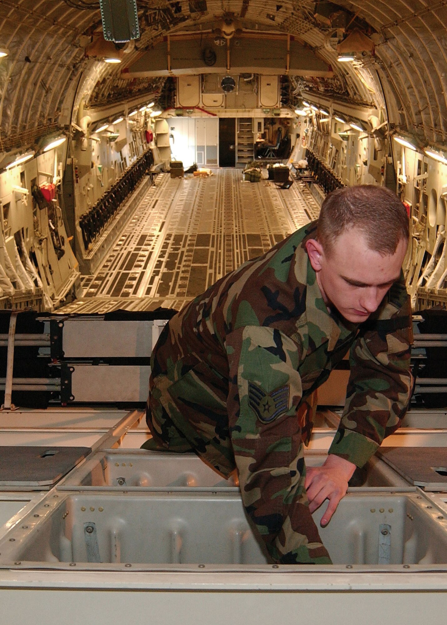 MCCHORD AIR FORCE BASE, Wash., - Staff Sgt. Steven Means, an aircraft maintenance craftsman with the 446th Aircraft Maintenance Squadron, looks through compartments in the back of a C-17 Globemaster. (U.S. Air Force photo by Kevin Tosh)

