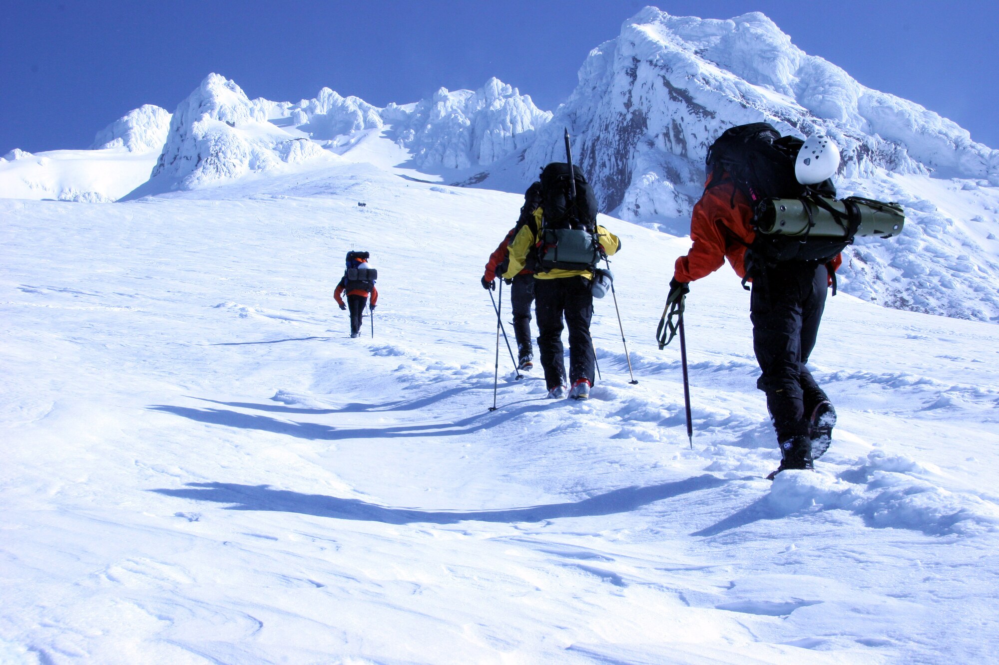 Master Sgts. Scott Light (left) and Eric Giacchino, Tech. Sgt. John Davis, 304th Rescue Squadron pararescuemen and Capt. Quintin Nelson, 304th RQS combat rescue officer use ice axes and ski [walking] poles to climb the icy mountain while searching for two lost climbers during a search and rescue scenario on Mount Hood, Ore. April 22, 2006.  The pararescuemen are wearing an urban SAR uniform used when participating in joint training exercises with civilian organizations with in the community. (U. S. Air Force Photo/Ruby Zarzyczny)