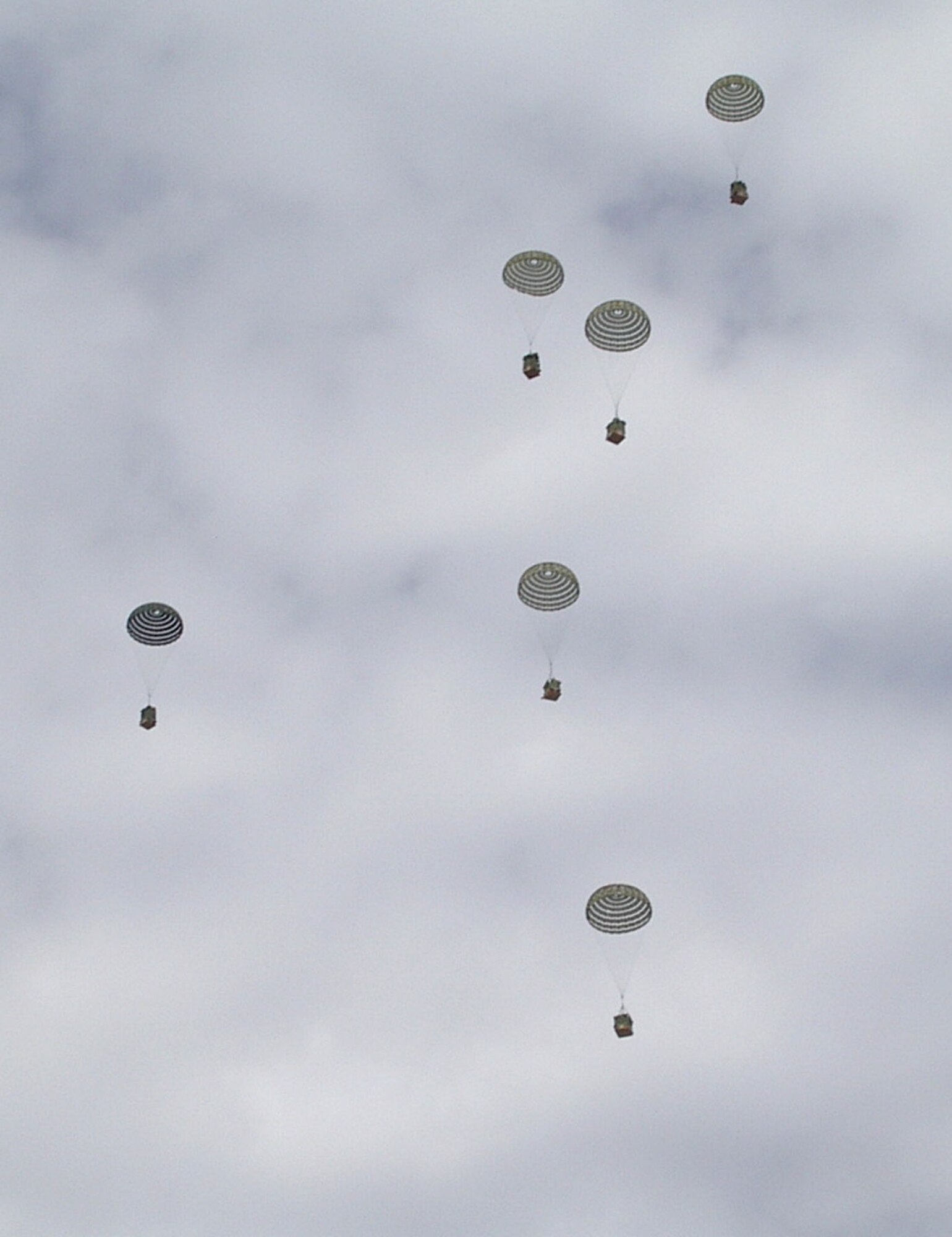 Palletized containers containing food, clothes, water, medical supplies and fuel fall near the village of Arawara Bandeh, Afghanistan, on Sunday, April 23, 2006. The bundles were dropped from C-130 Hercules with the 774th Expeditionary Airlift Squadron at Bagram Air Base. They have delivered more than 30,000 pounds of humanitarian supplies since Operation Mountain Lion began April 12. (U.S. Air Force photo/Capt. Timothy Kelly) 
