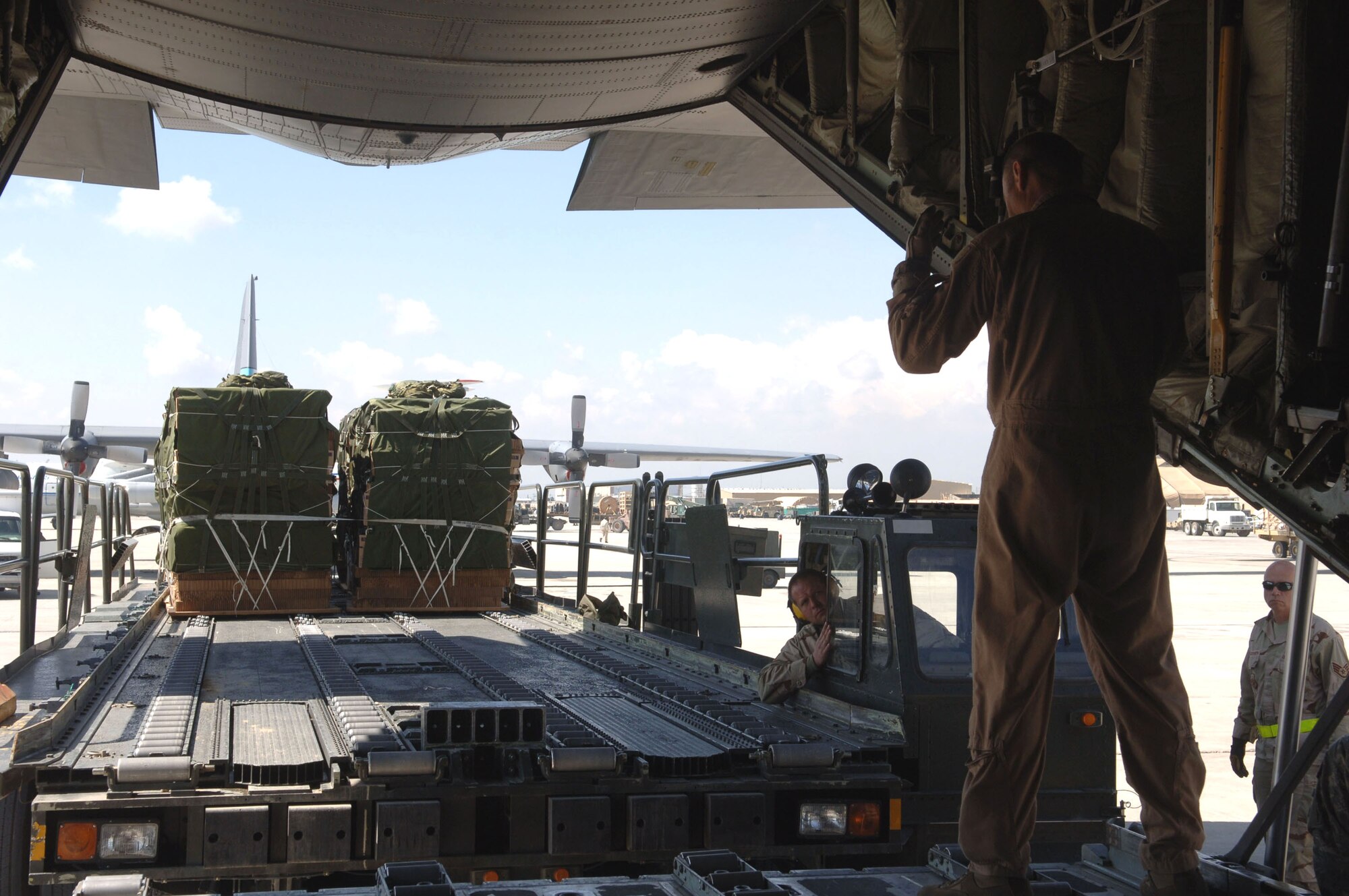 Staff Sgt. John Ploucher pulls into position to load pallets onto a C-130 Hercules at Bagram Air Base, Afghanistan, on Saturday, April 15, 2006. Sergeant Ploucher is an air cargo transportation journeyman assigned to the 455th Expeditionary Logistics Readiness Squadron. (U.S. Air Force photo/Staff Sgt. Jennifer Redente) 
