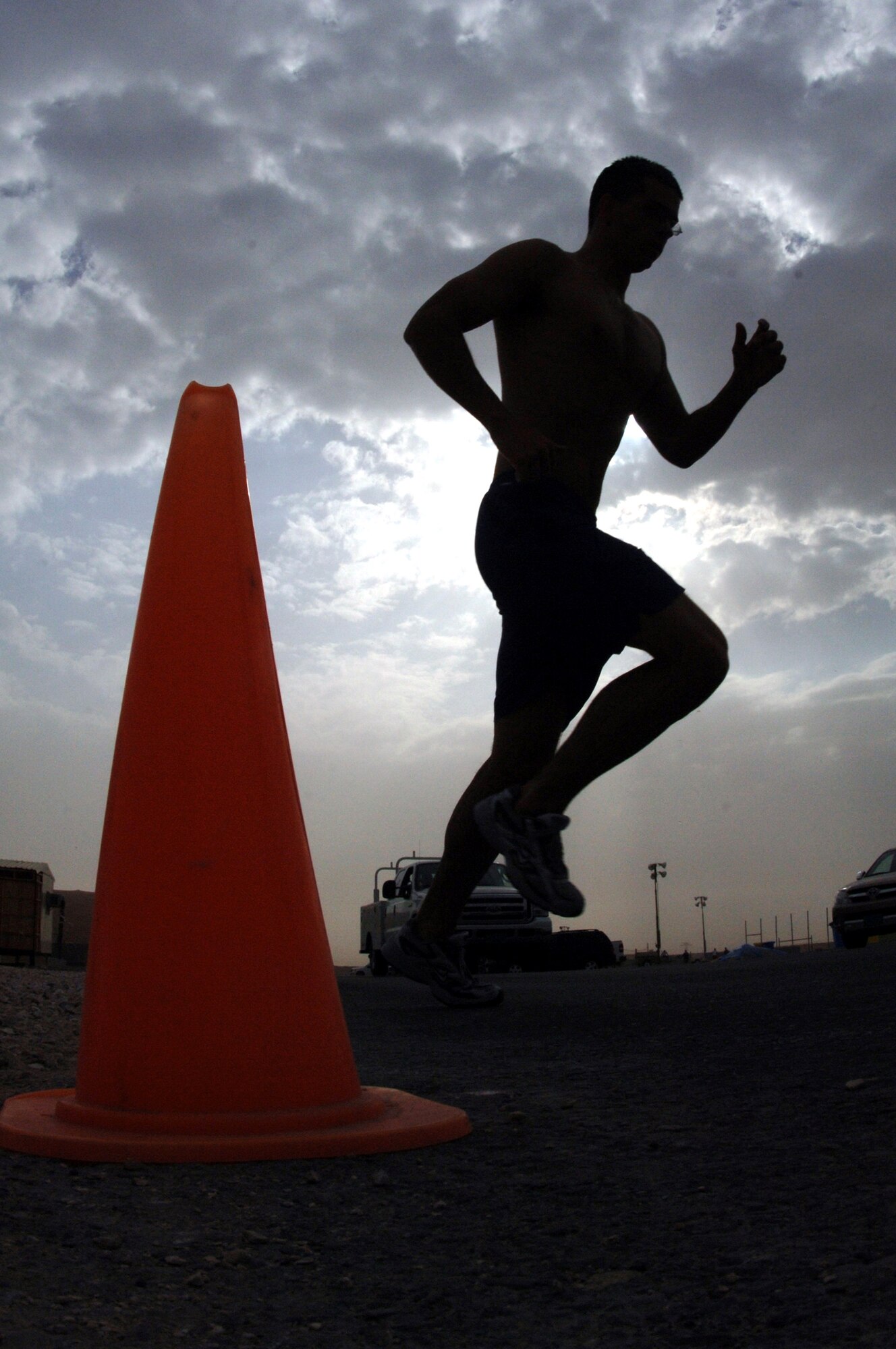 An Airman is silhouetted as he runs in the biathlon portion of the 379th Air Expeditionary Wing Sports Day on Sunday, April 23, 2006. The biathlon consisted of a 1,600-meter swim and 5-kilometer run. Other events at the deployed location in Southwest Asia included volleyball, a home run derby, basketball, dodgeball and a "strongman and woman" contest. (U.S. Air Force photo/Staff Sgt. Joshua Strang)