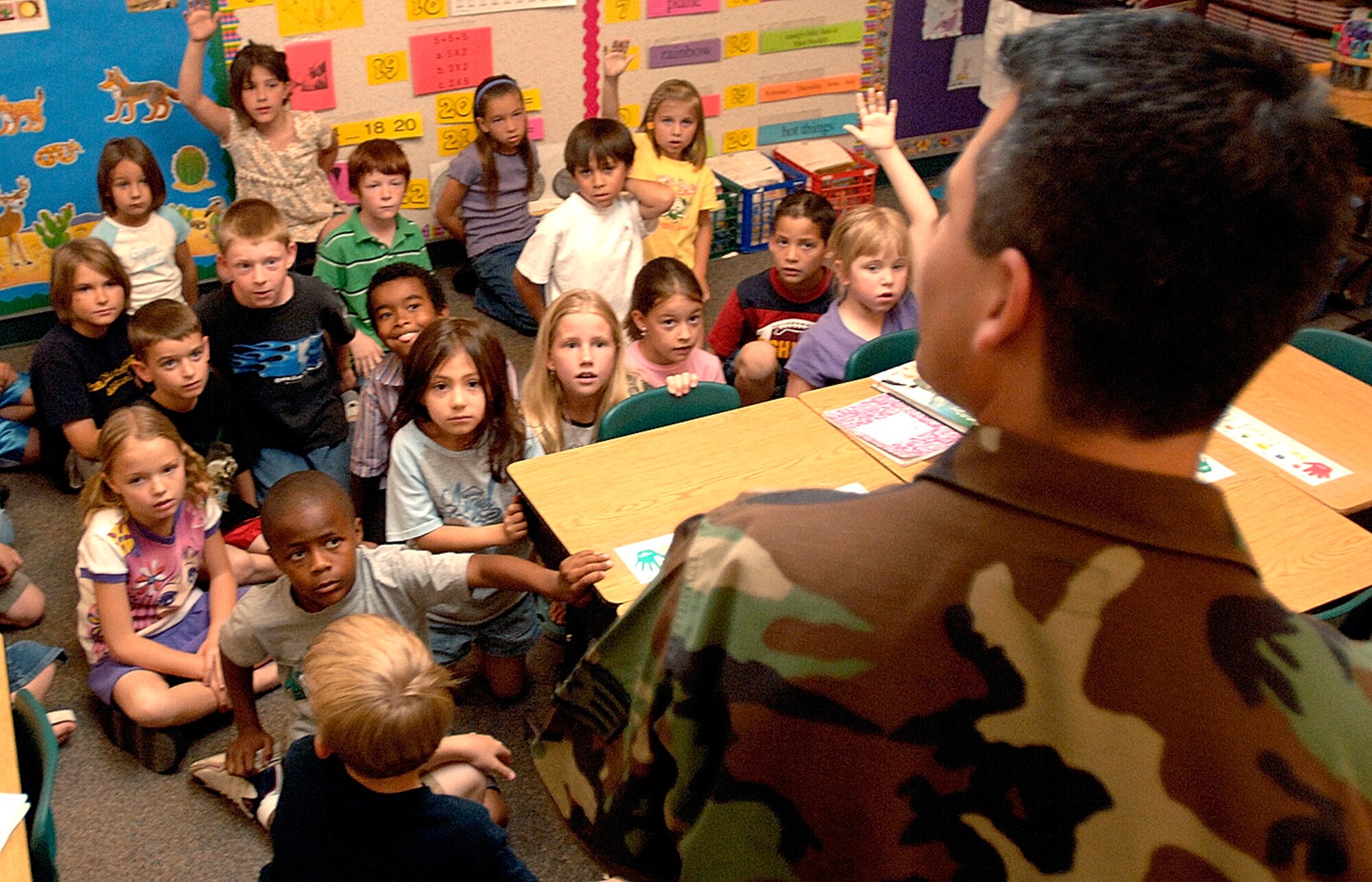 Staff Sgt. Milo Munoz hands out recycling bags to children at Palm Valley Elementary School in Phoenix, Ariz., on Thursday, April 20, 2006. Sergeant Munoz, a crew chief with the 308th Aircraft Maintenance Unit at nearby Luke Air Force Base, volunteers to help promote Air Force environmental programs. (U.S. Air Force photo/Tech. Sgt Cecilio M. Ricardo Jr.)


